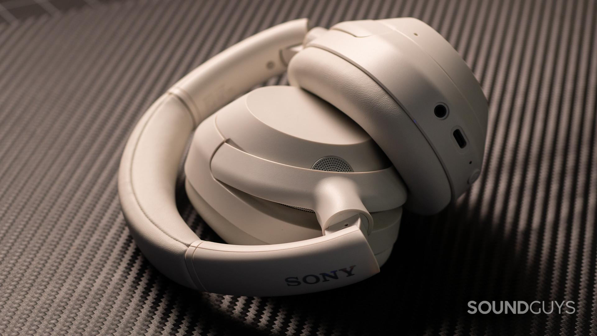 A photo of the Sony ULT WEAR headphones, foleded up atop a desk.