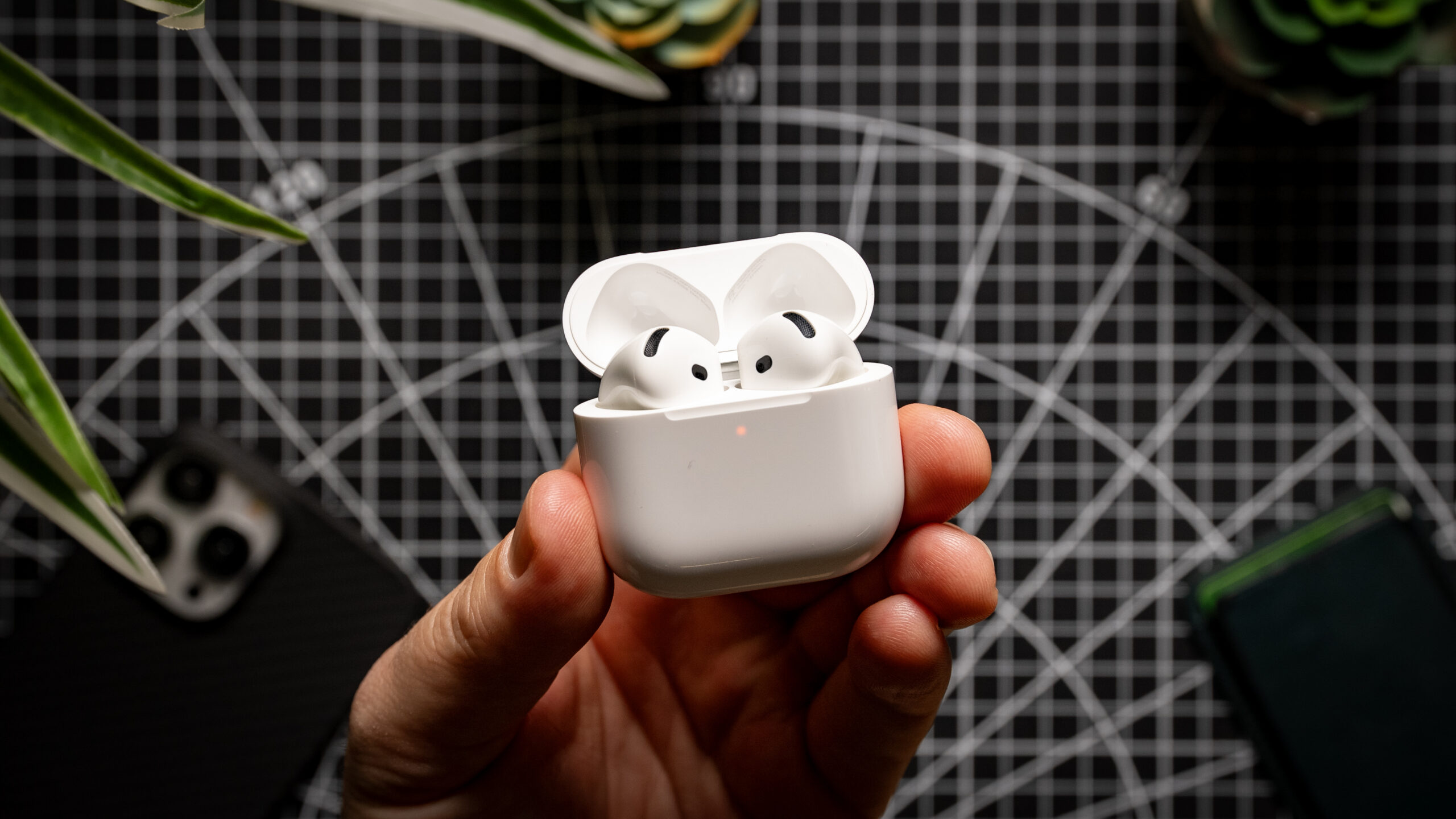 Apple AirPods 4 in hand case open top down