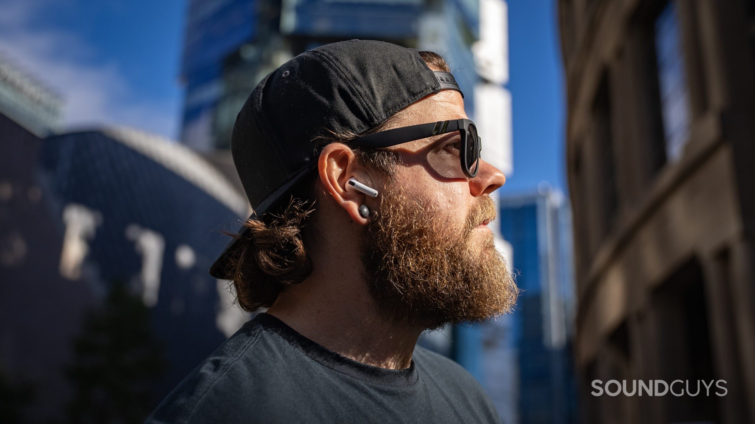 Apple AirPods 4 side profile man wearing outside library 3 a man wearing the airpods 4 outside