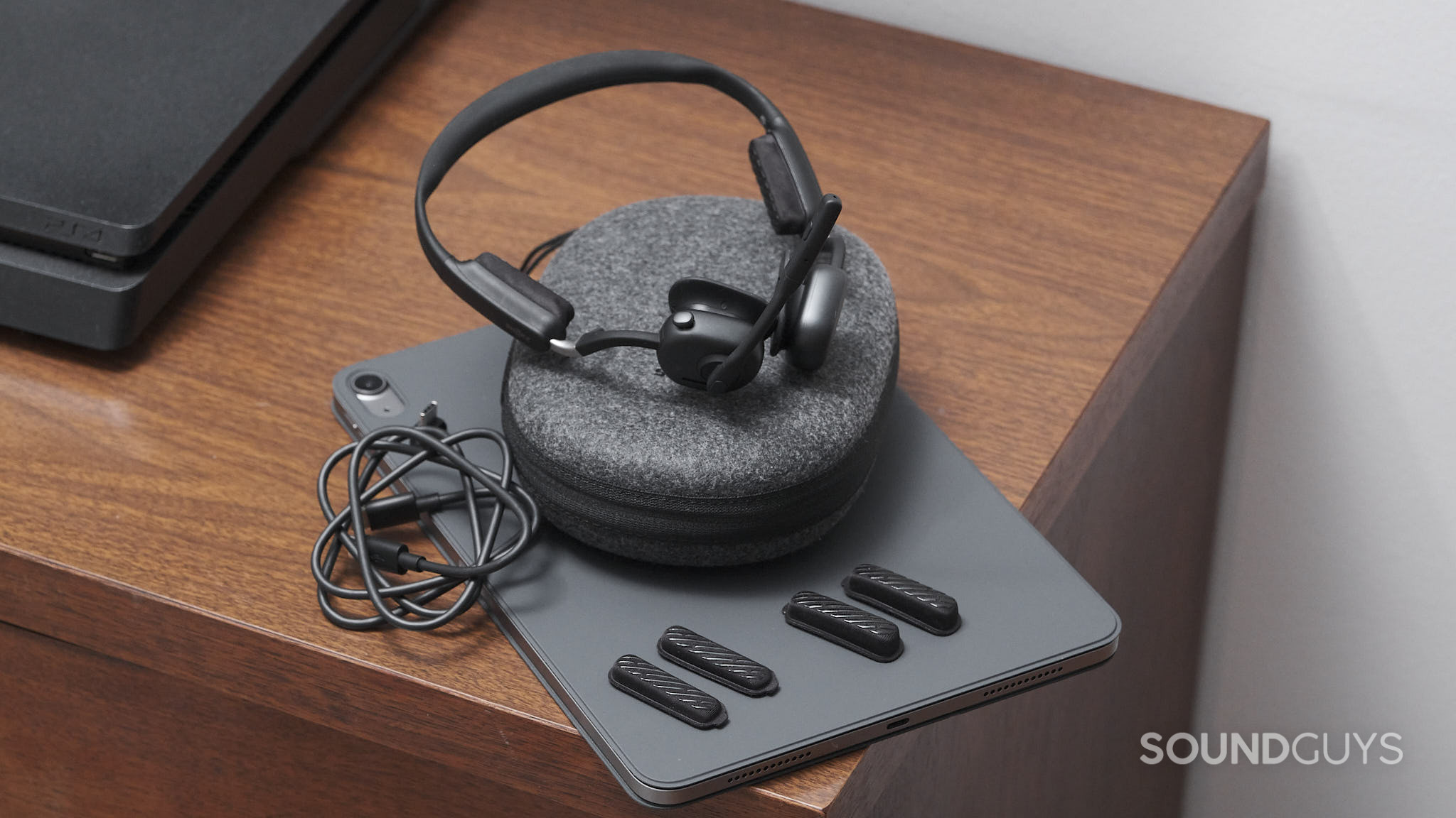 Shokz OpenMeet UC-accesories The Shokz OpenMeet UC and its accessories lie on an iPad.