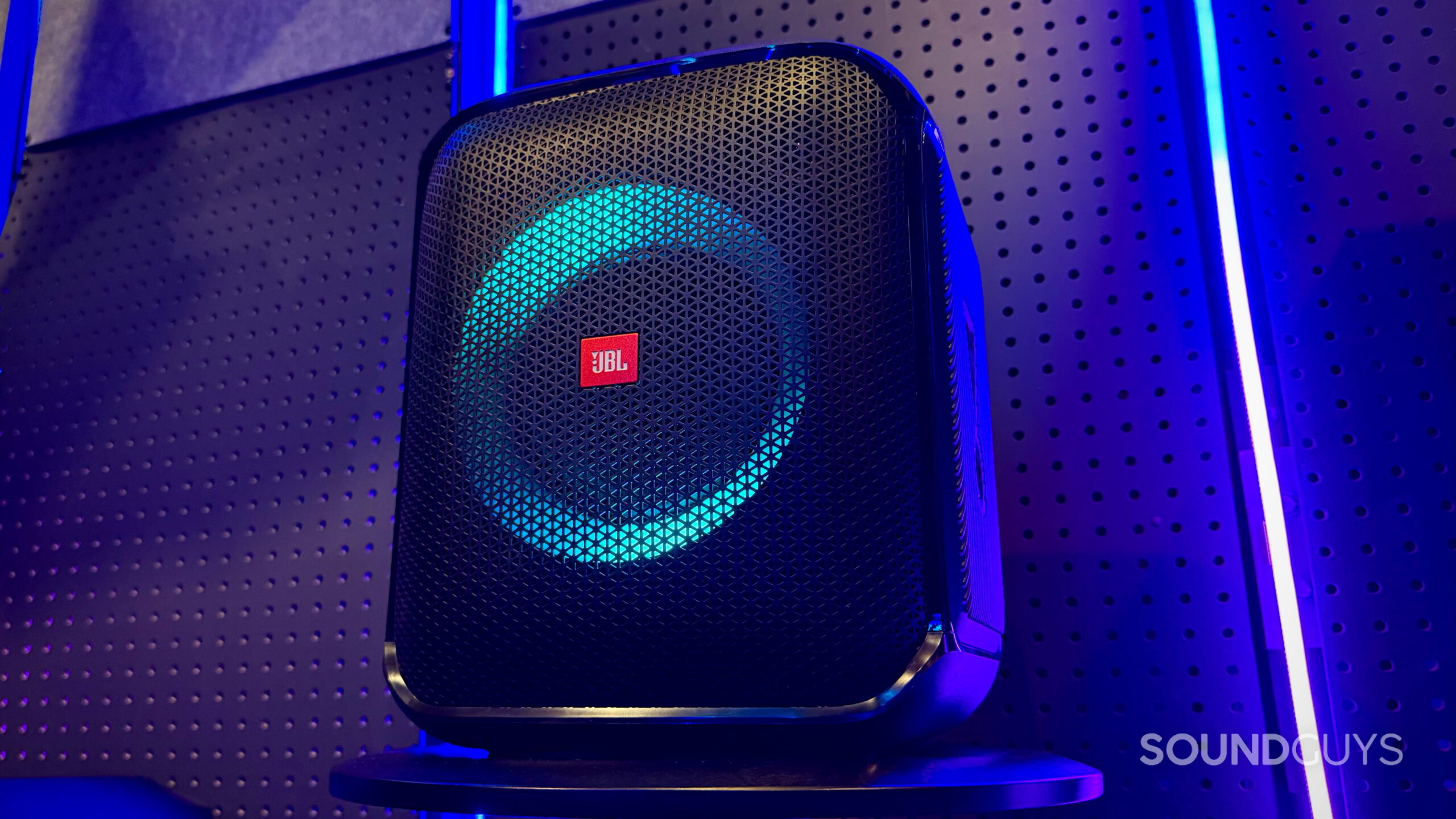 Encore PartyBox - 3 A JBL PartyBox Encore Essential speaker on a stool with neon lights in the background