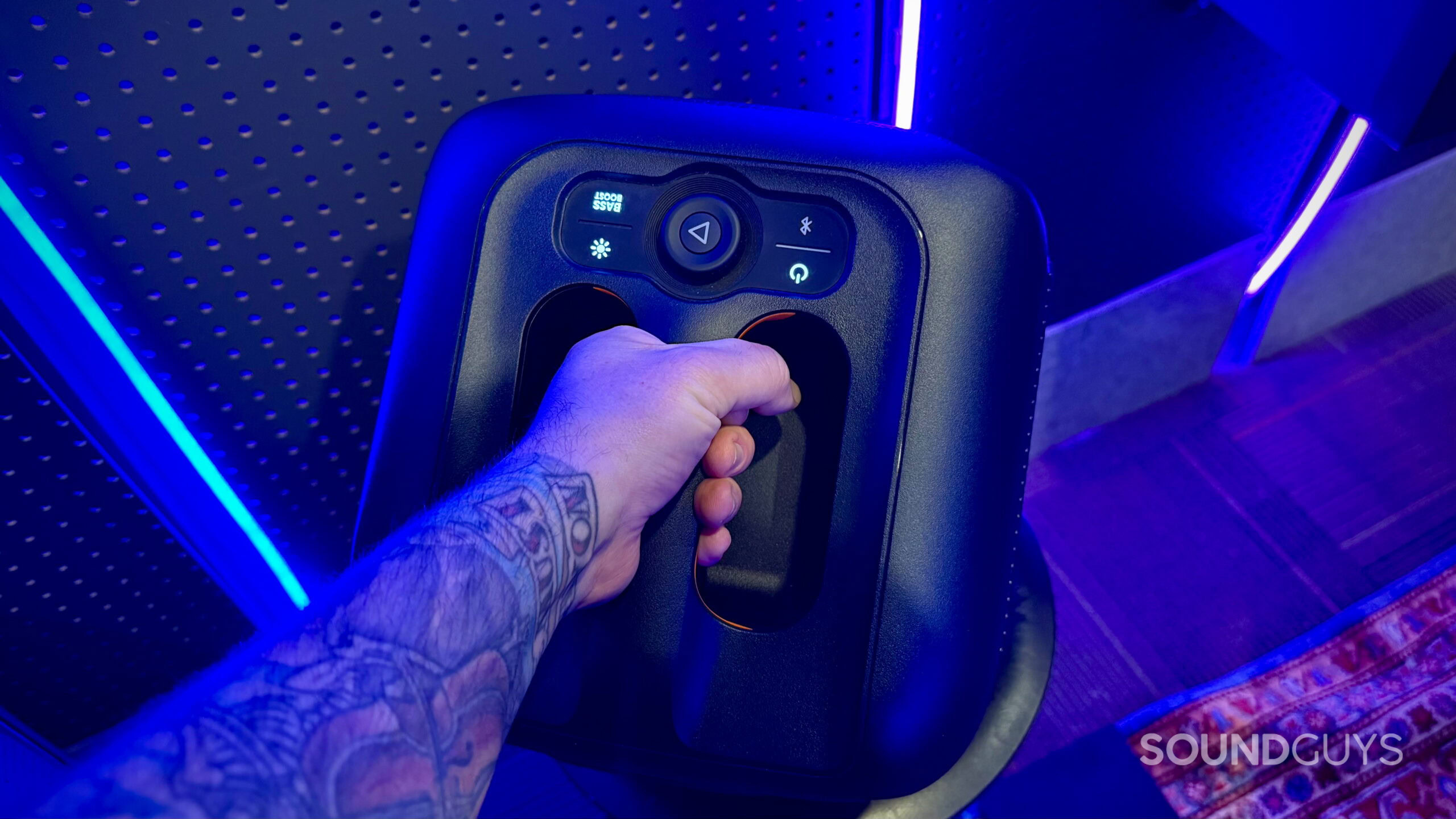 An extended out arm holding the JBL Partybox Encore Essential by its handel.