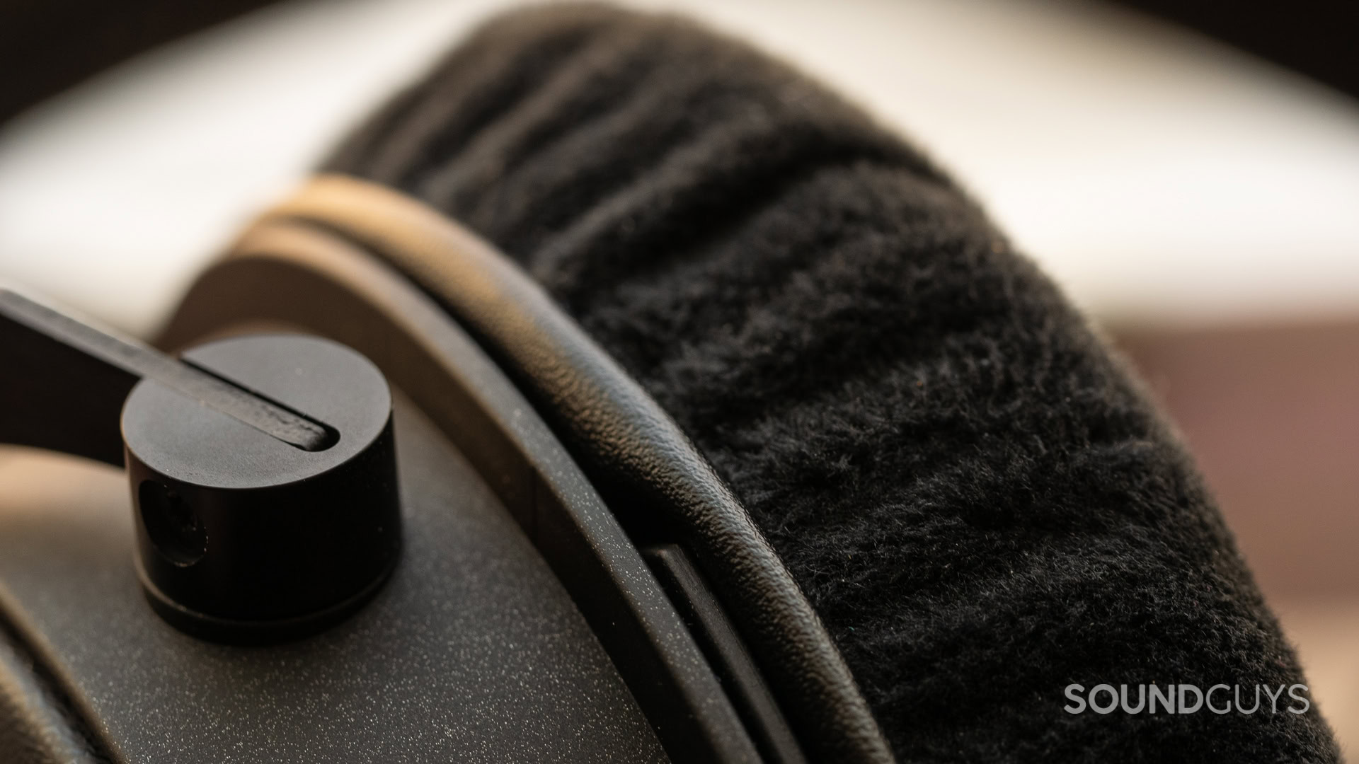 A photo of the ear pad being slid into place.