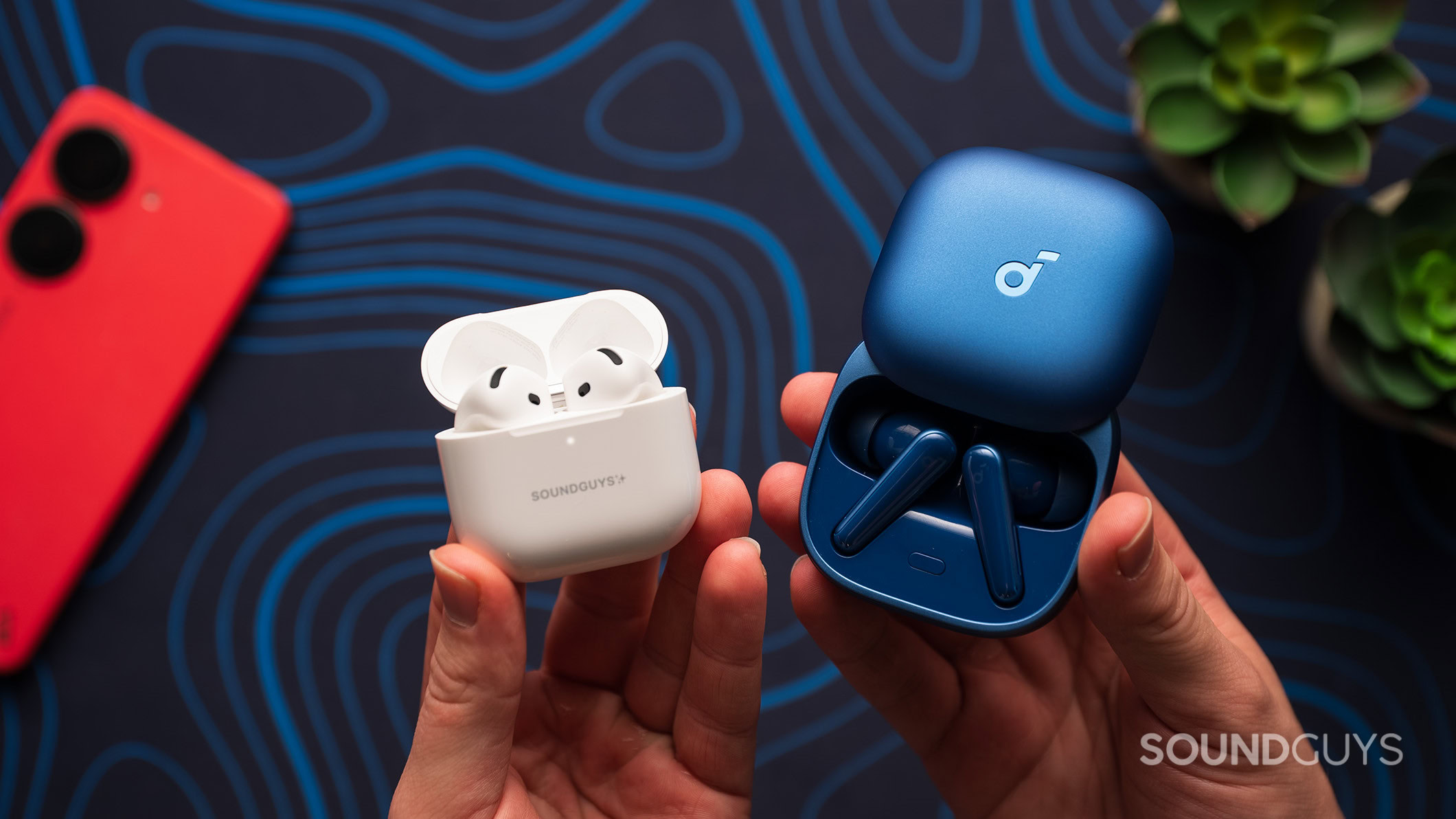 Anker Soundcore Liberty 5 next to Apple AirPods 4 with the case lid open Anker Soundcore Liberty 5 next to Apple AirPods 4 earbuds in charging case.