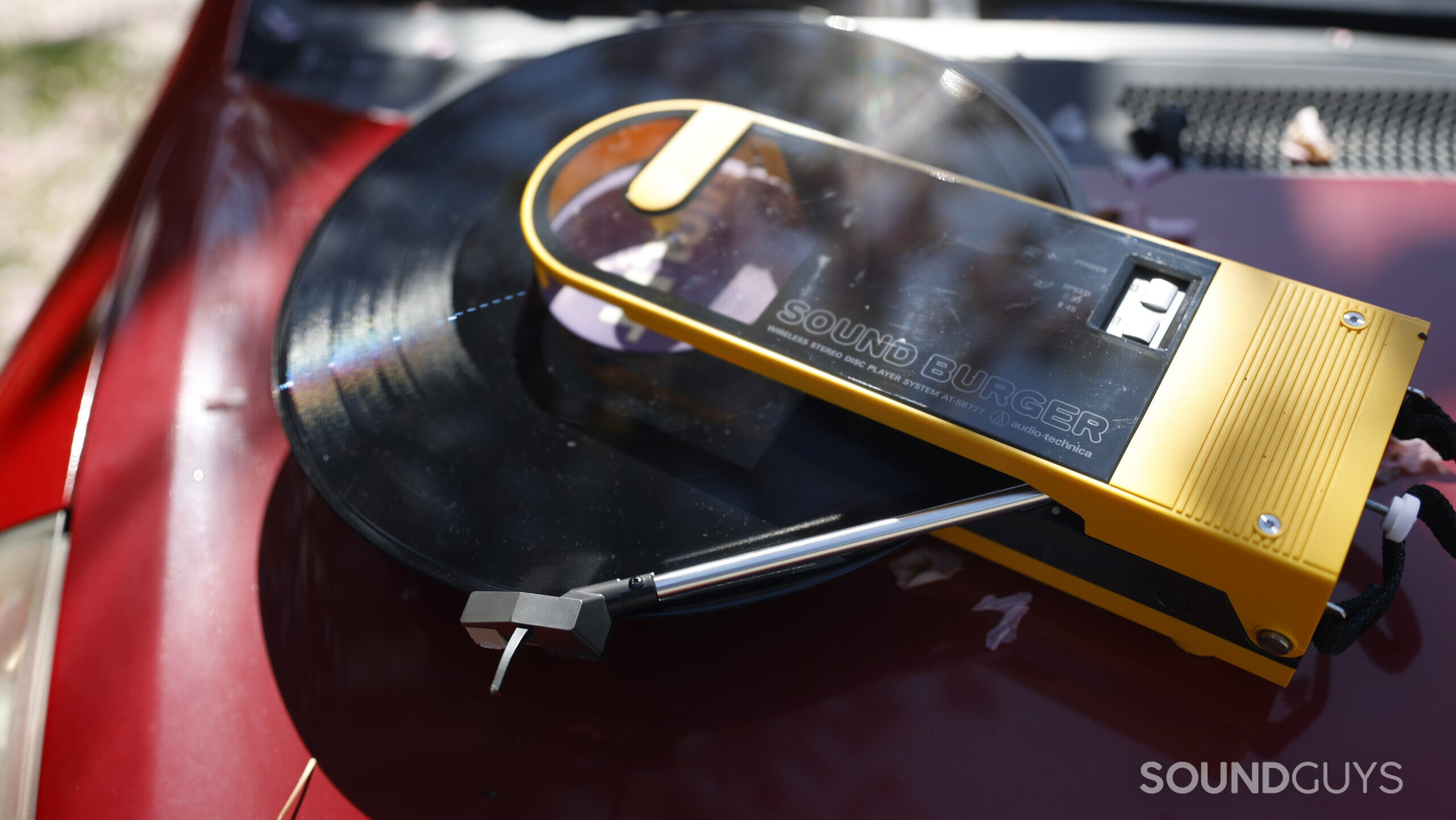 Soundburger-Car-1 The Sound Burger sits on the hood of a red hatchback, playing a record.