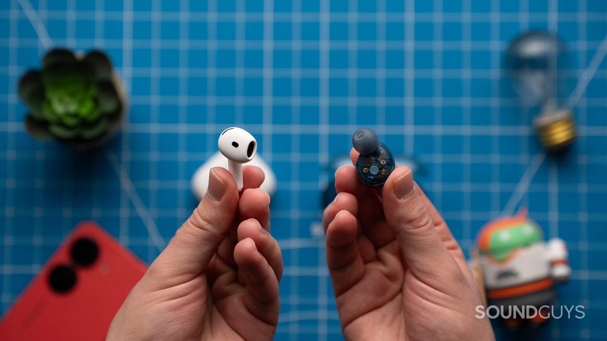 Sony WF-C710N and AirPods 4 earbuds A hand holding an AirPods 4 earbud next to a hand holding a C710N earbud.
