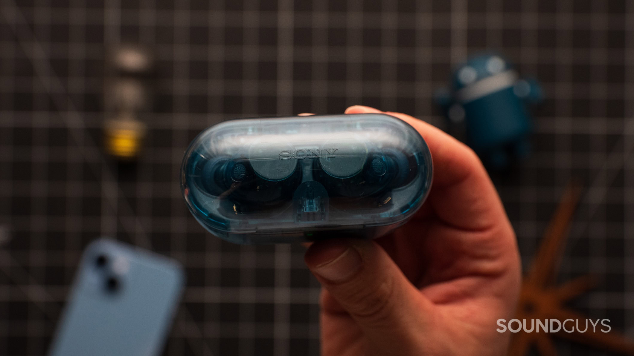 A hand holds the Sony WF-C710N earbud case.