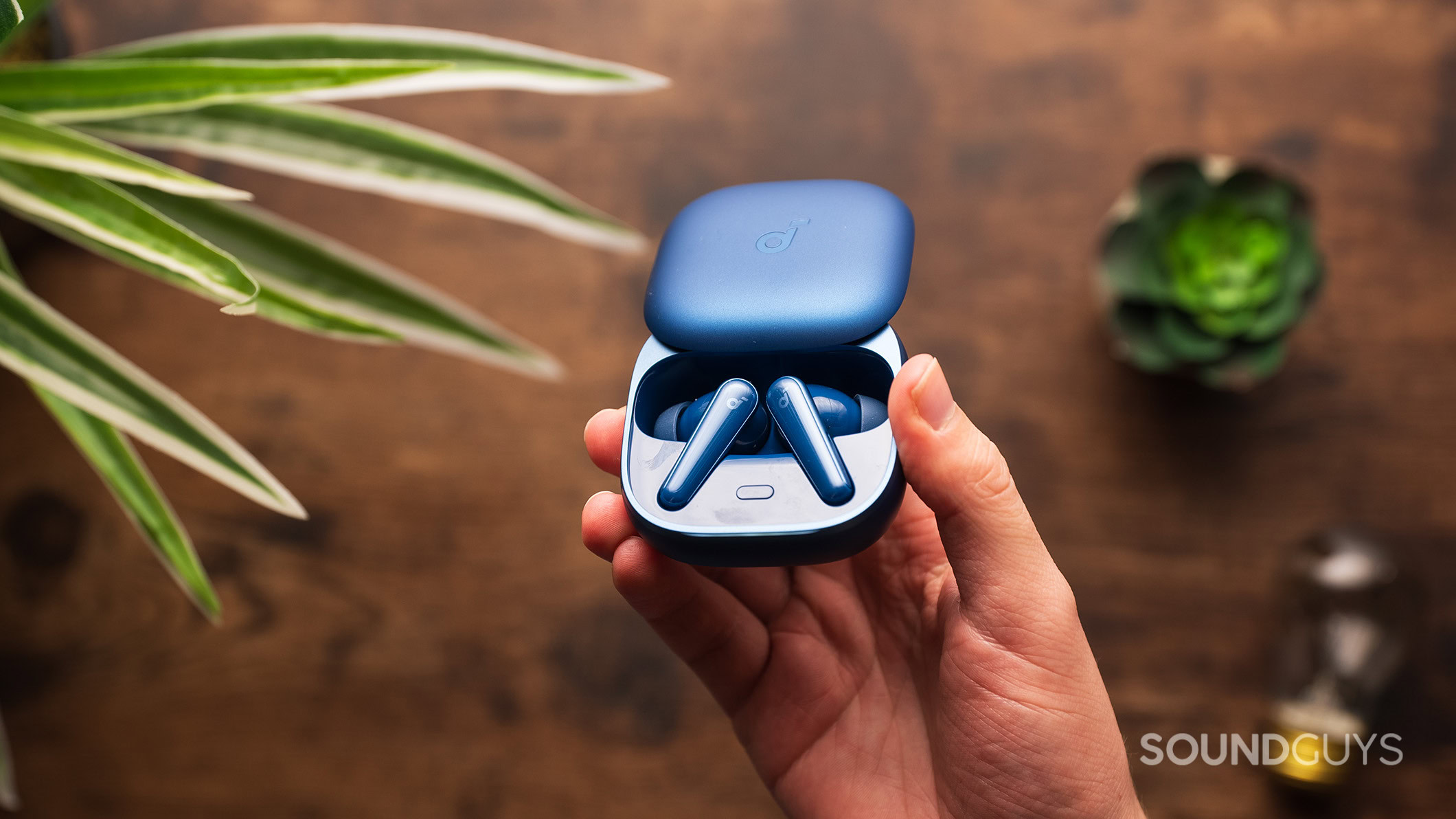 Soundcore Liberty 5 earbuds in case angle A hand holding the Anker Soundcore Liberty 5 earbuds.