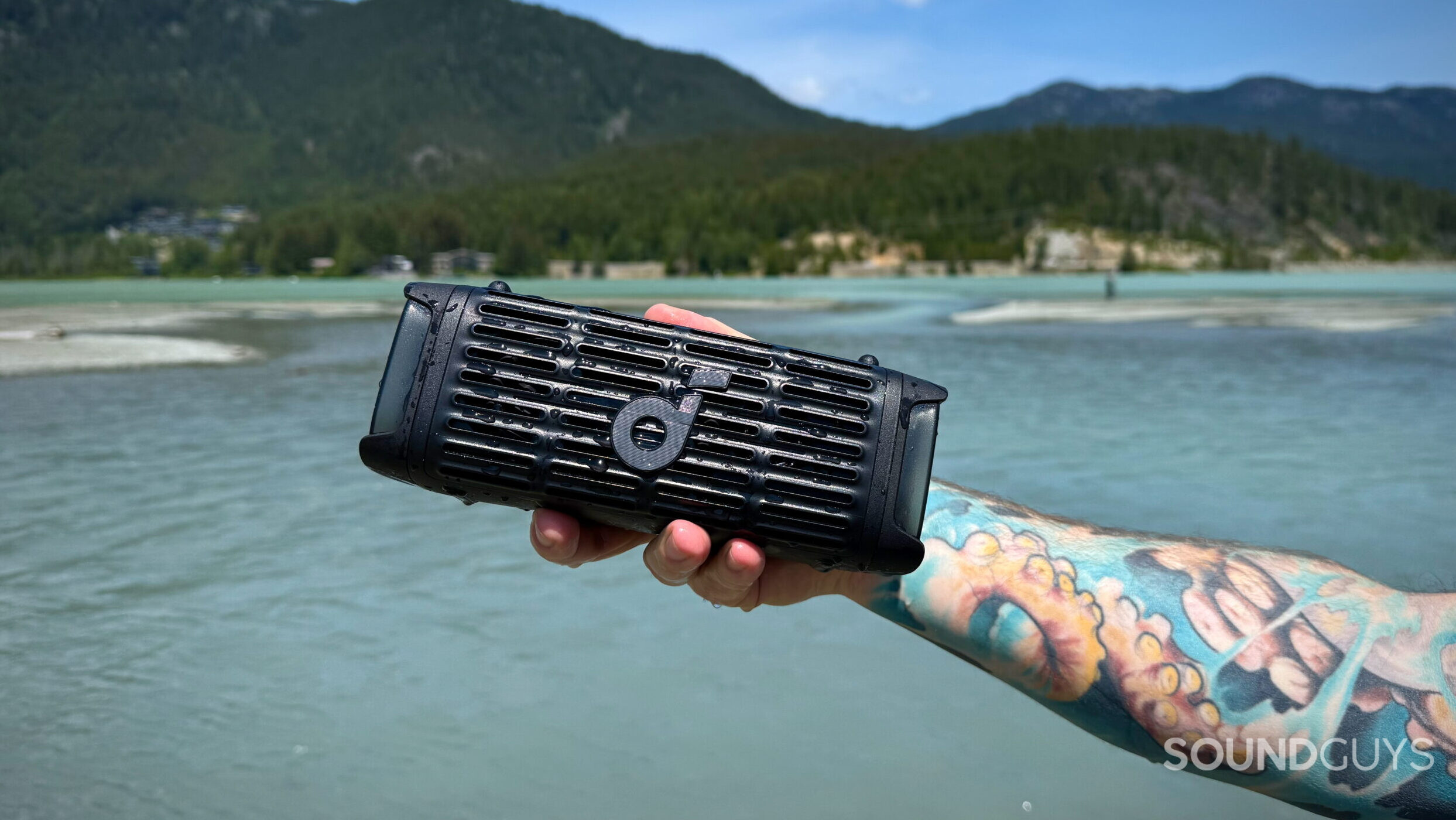 Boom 3i - 4 A hand holds the Soundcore Boom 3i in front of a lake.