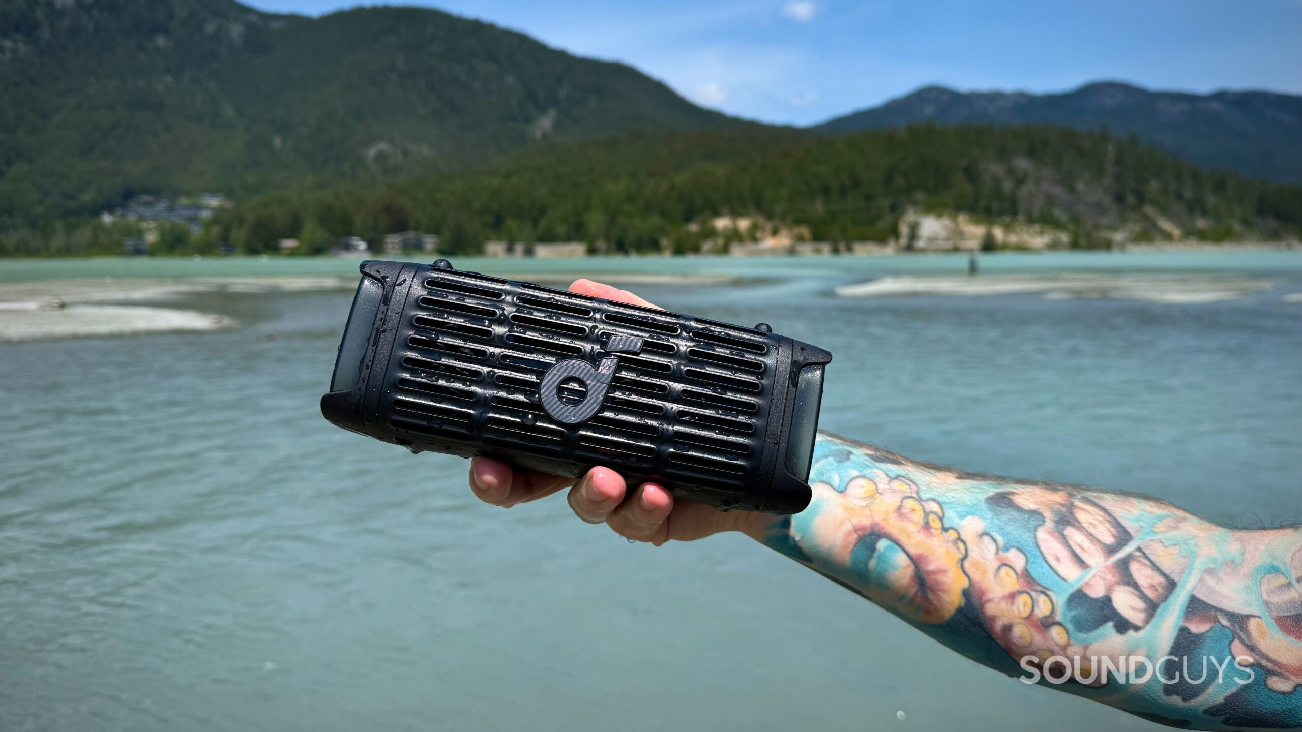 Boom 3i - 4 A hand holds the Soundcore Boom 3i in front of a lake.