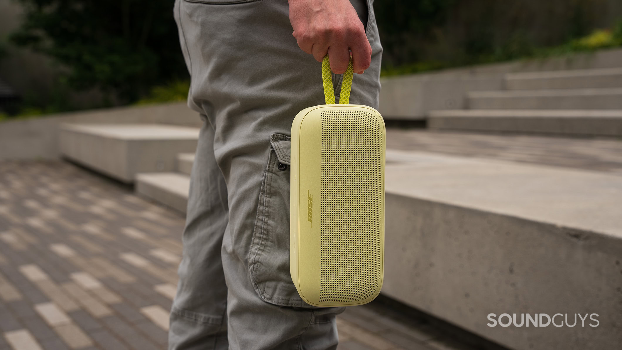 Bose SoundLink Plus held by strap A hand holds the Bose SoundLink Plus by its carrying loop.