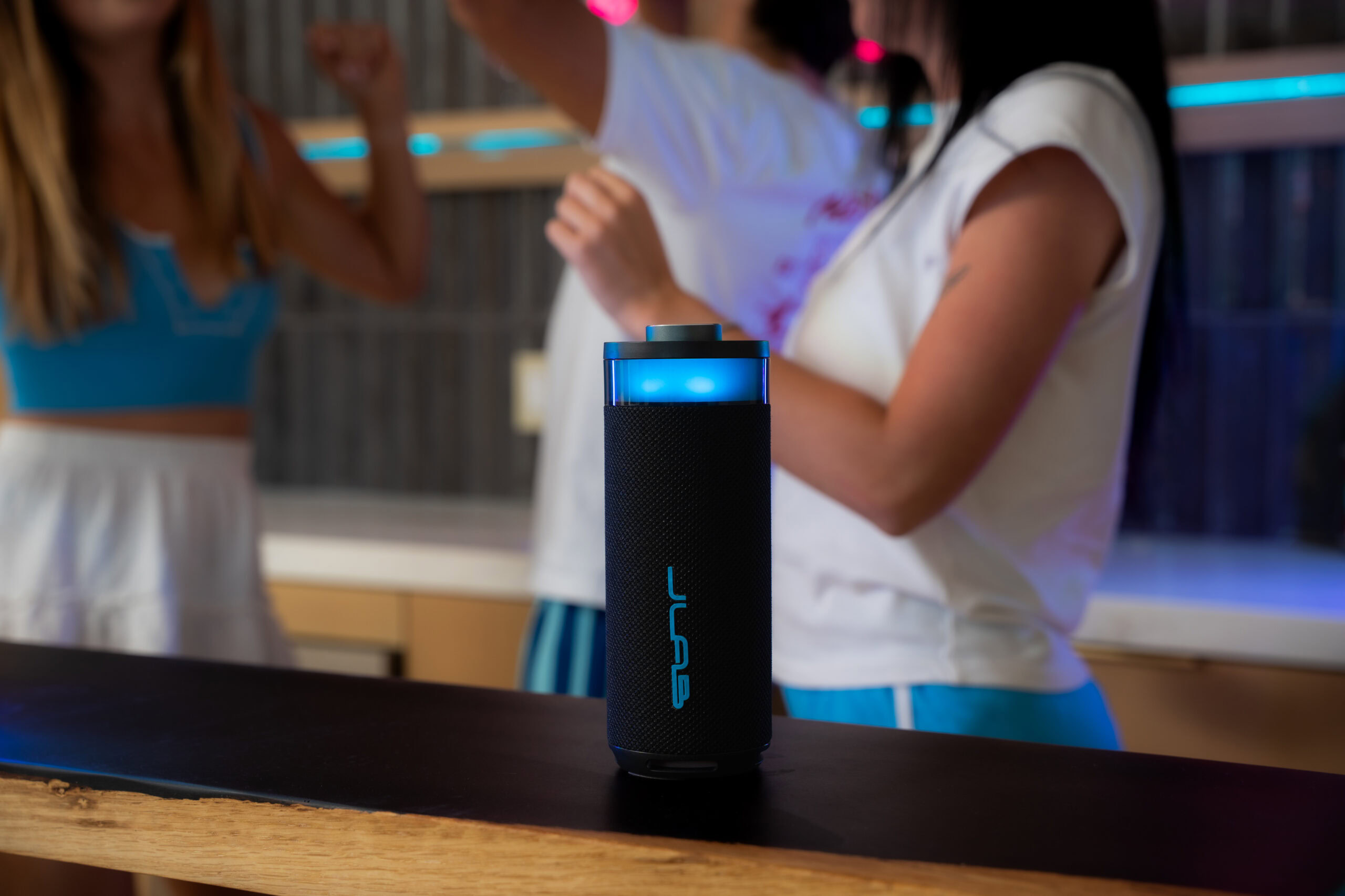 JLab-Go Party Speaker-Lifestyle-Black-HiRes-Driver & Woofer-1 JLab Go party speaker on a table at a party.