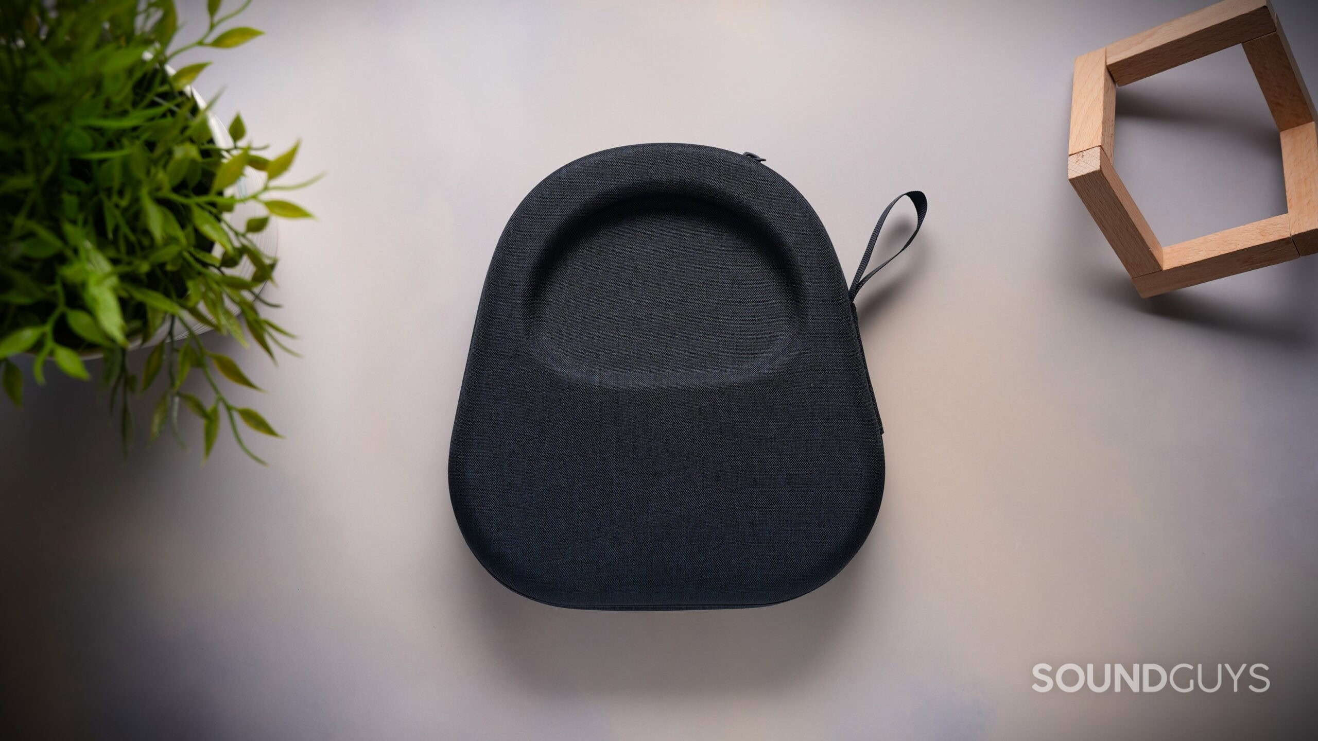 Rear view of the black fabric carrying case for the Sennheiser MOMENTUM 5 Wireless headphones on a light tabletop.