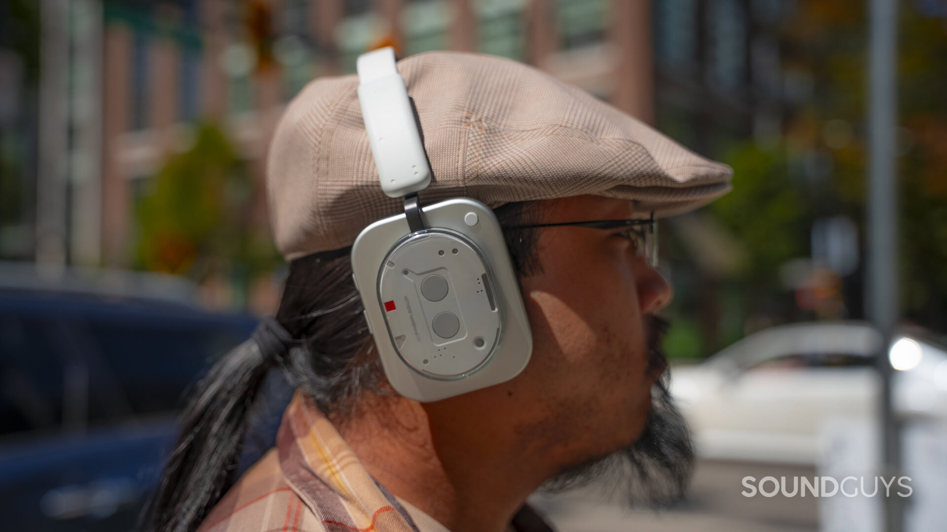 a profile shot of a man wearing the Nothing Headphone (1) outside.