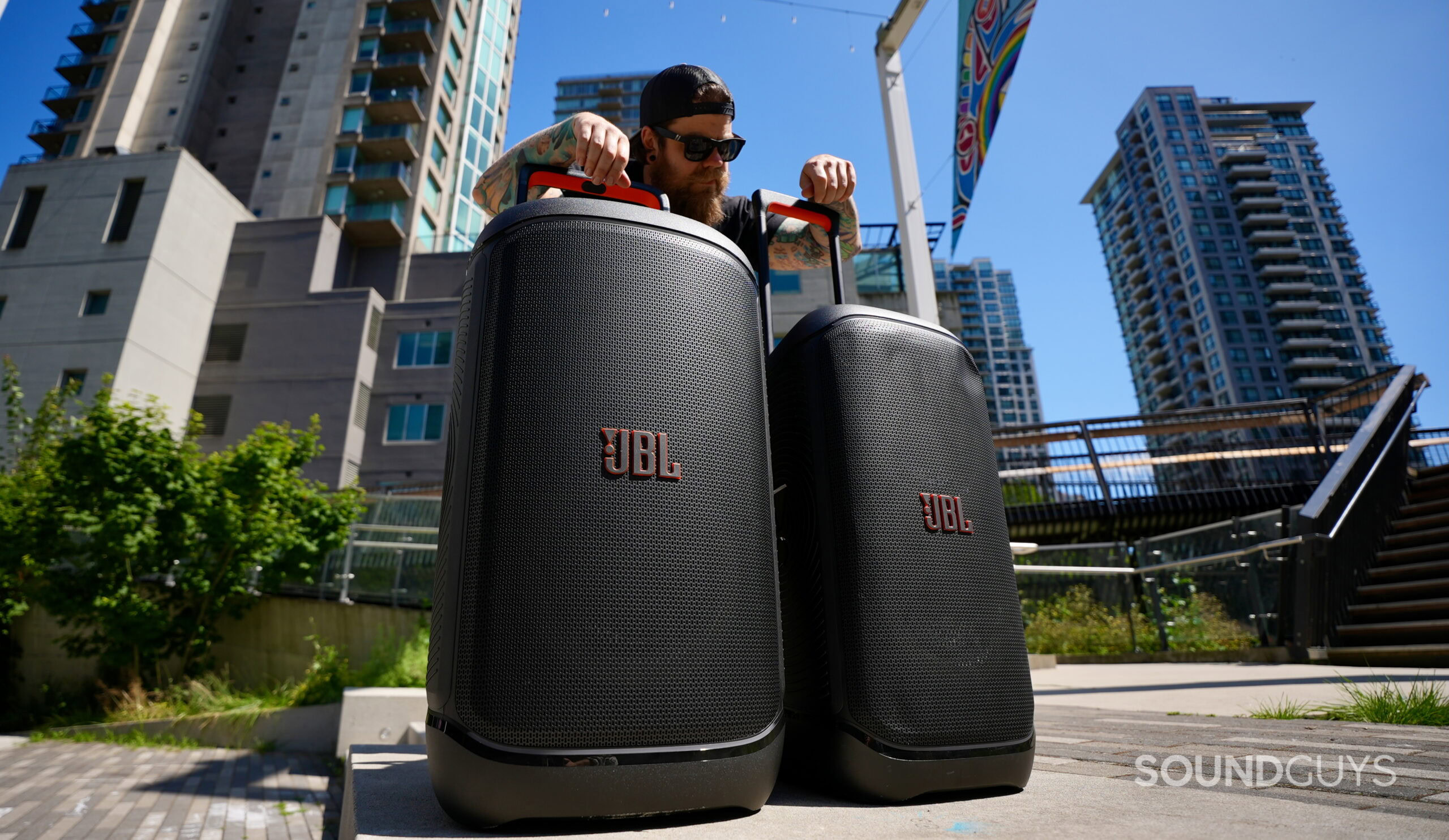 520_Hero - 1 A man standing behind a JBL PartyBox 520 and PartyBox Stage 320