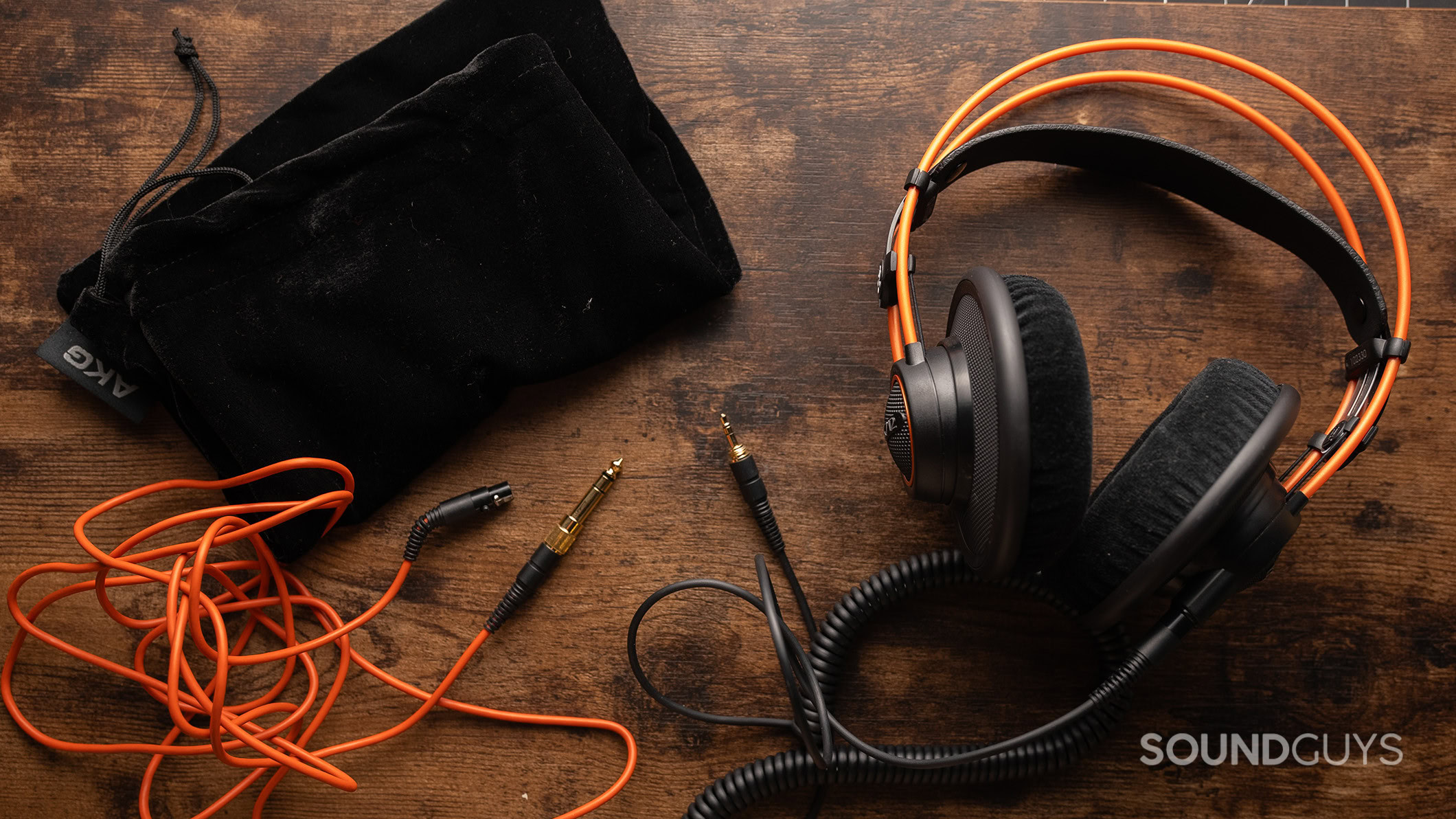 The AKG K712 PRO headphones on a table with the included cables.