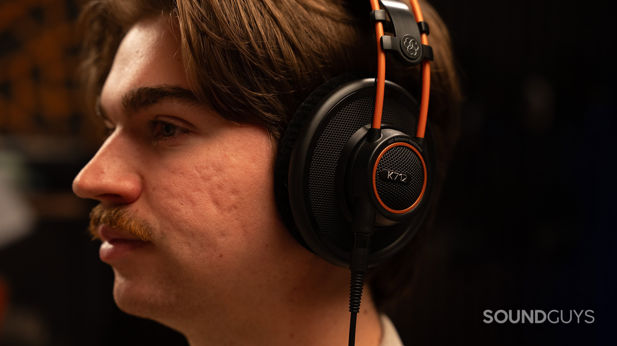 AKG K712 headphones on man A man wearing the AKG K712 PRO headphones in a studio.