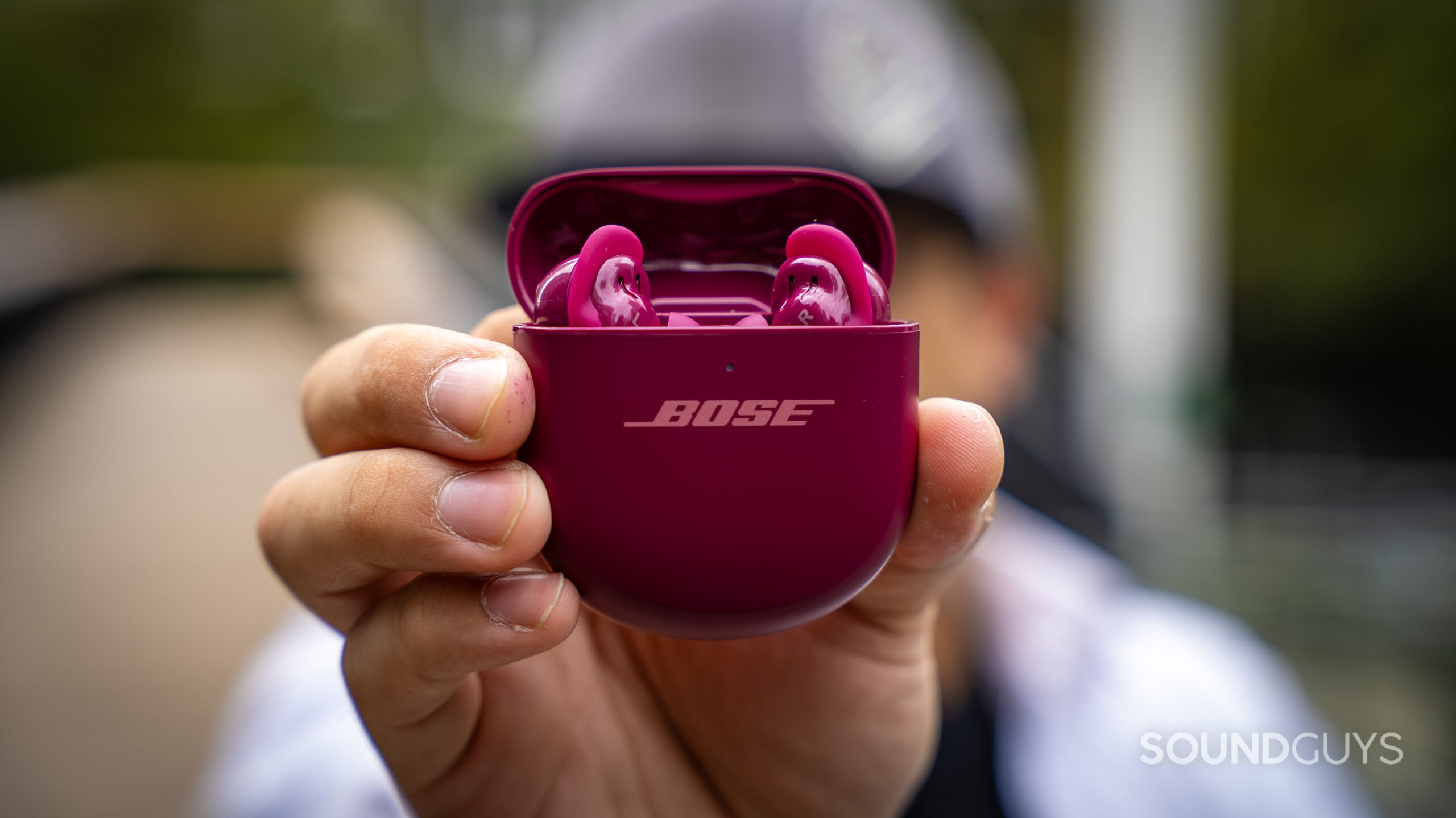 Bose QuietComfort Ultra Earbuds (2nd Gen)_34 A photo of a man holding the Bose QuietComfort Ultra Earbuds (2nd Gen.) close to the camera.