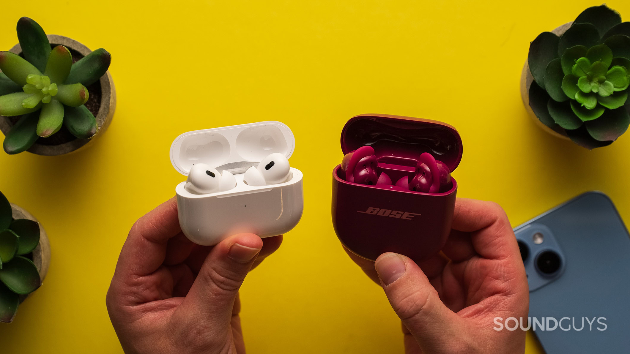 Bose QuietComfort Ultra Earbuds (2nd gen) vs AirPods Pro 2 case open Bose QuietComfort Ultra Earbuds (2nd gen) vs AirPods Pro 2 earbuds in case with lid open.