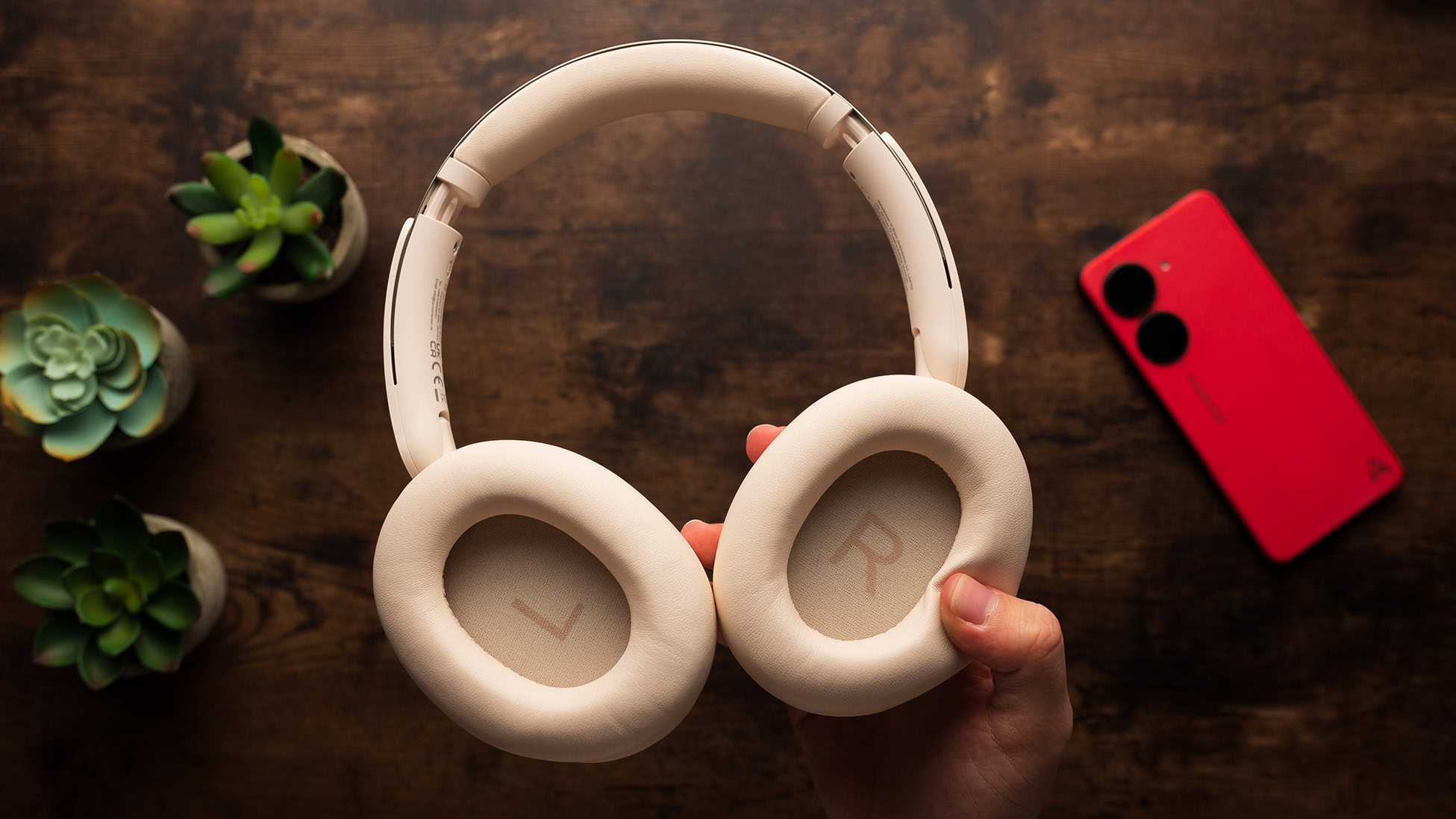A hand holds the OneOdio Focus A6 headphones.