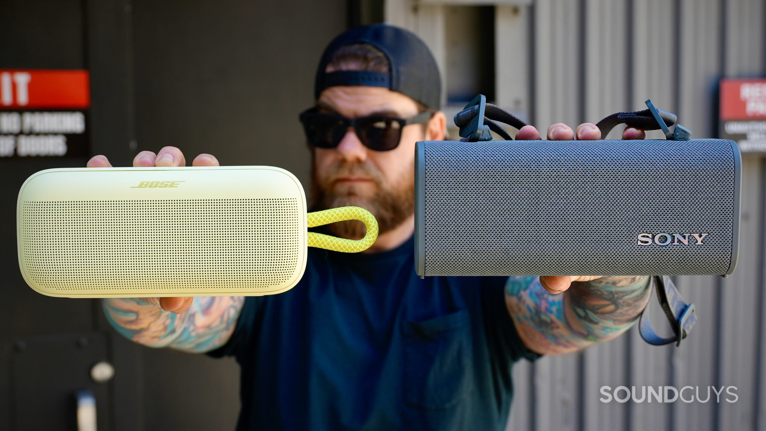 SL Plus Vs ULT Field 3 - 1 A man holding the Bose SoundLink Plus and Sony ULT Field 3 in front of his face.