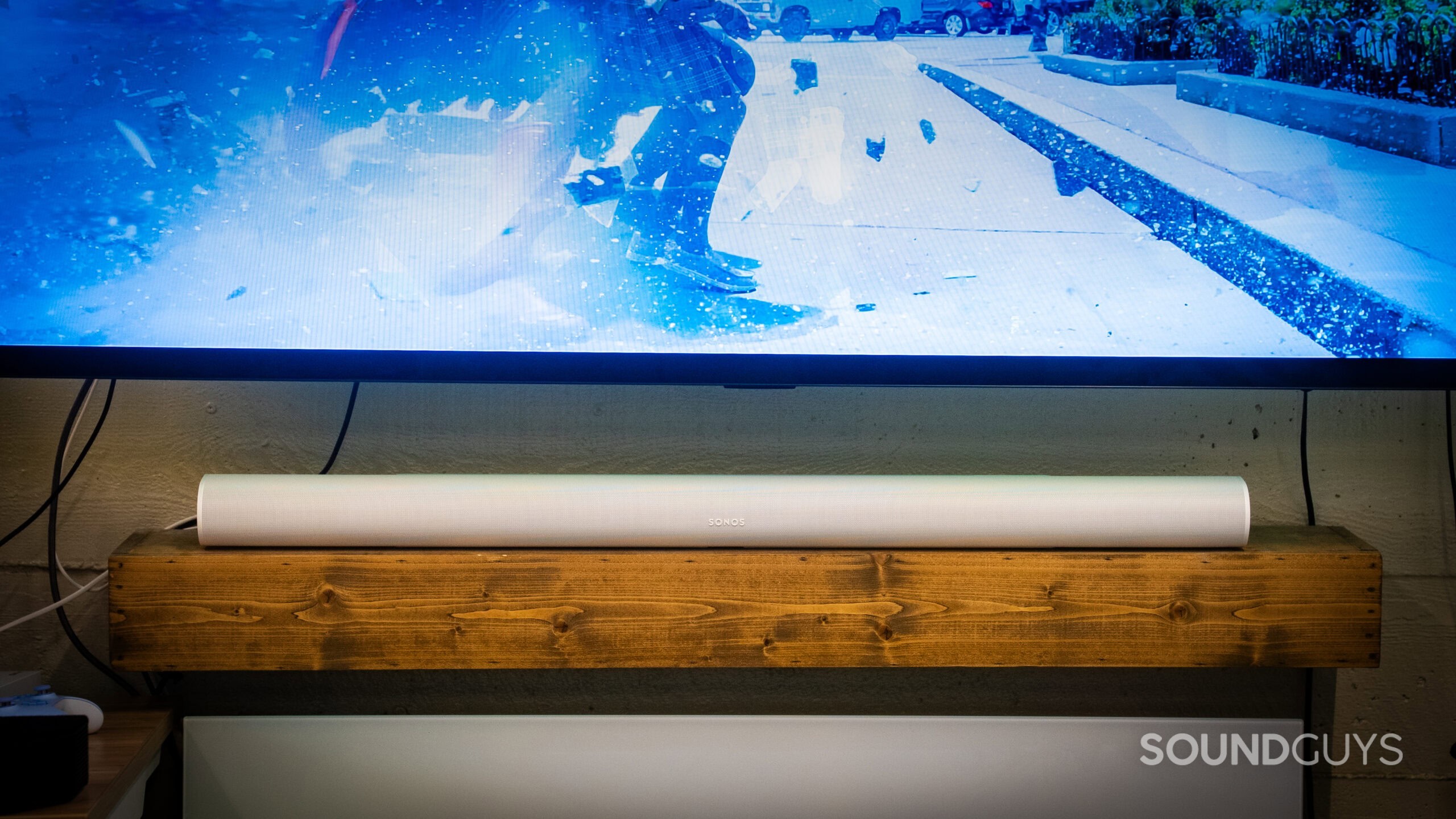 Sonos Arc Ultra + Sub_5 The Sonos Arc Ultra soundbar on a wooden shelf.