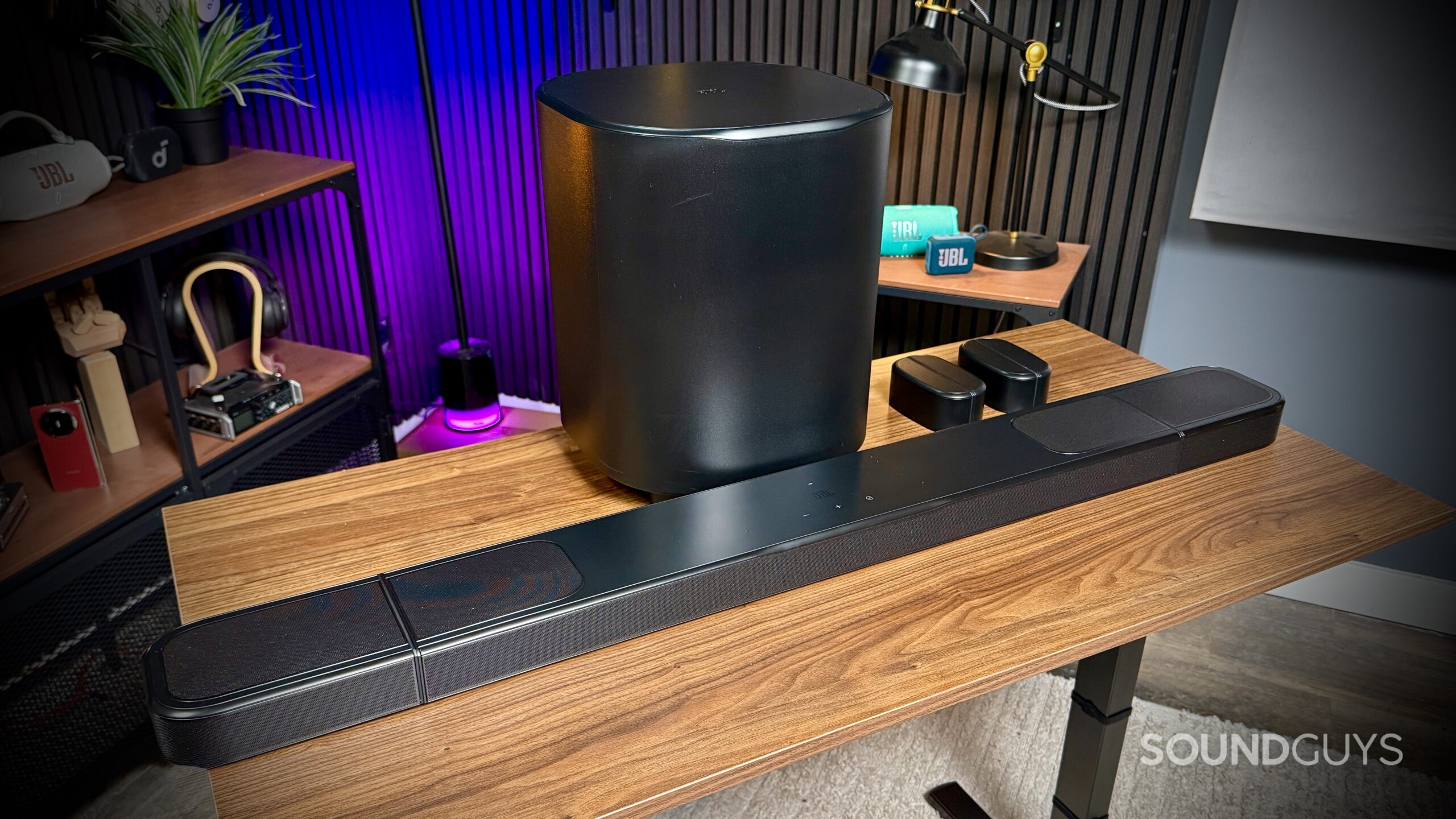 JBL Bar 1000MK2 - 1 Complete JBL BAR 1000MK2 system with subwoofer, soundbar, and both surround speakers docked in a home office setup.
