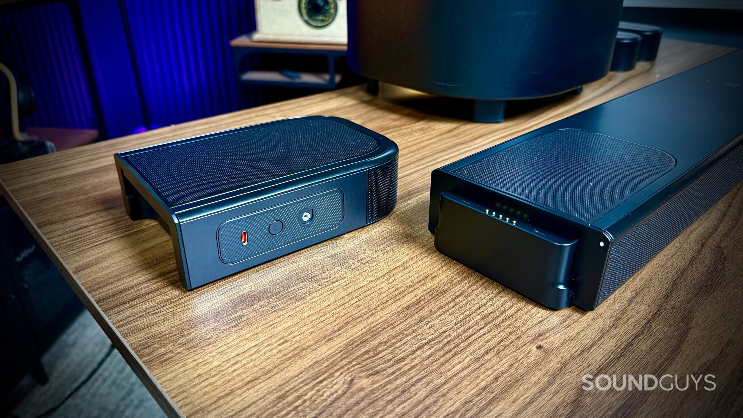 Close-up of the detachable JBL surround speaker’s power and USB-C charging controls next to the soundbar dock.