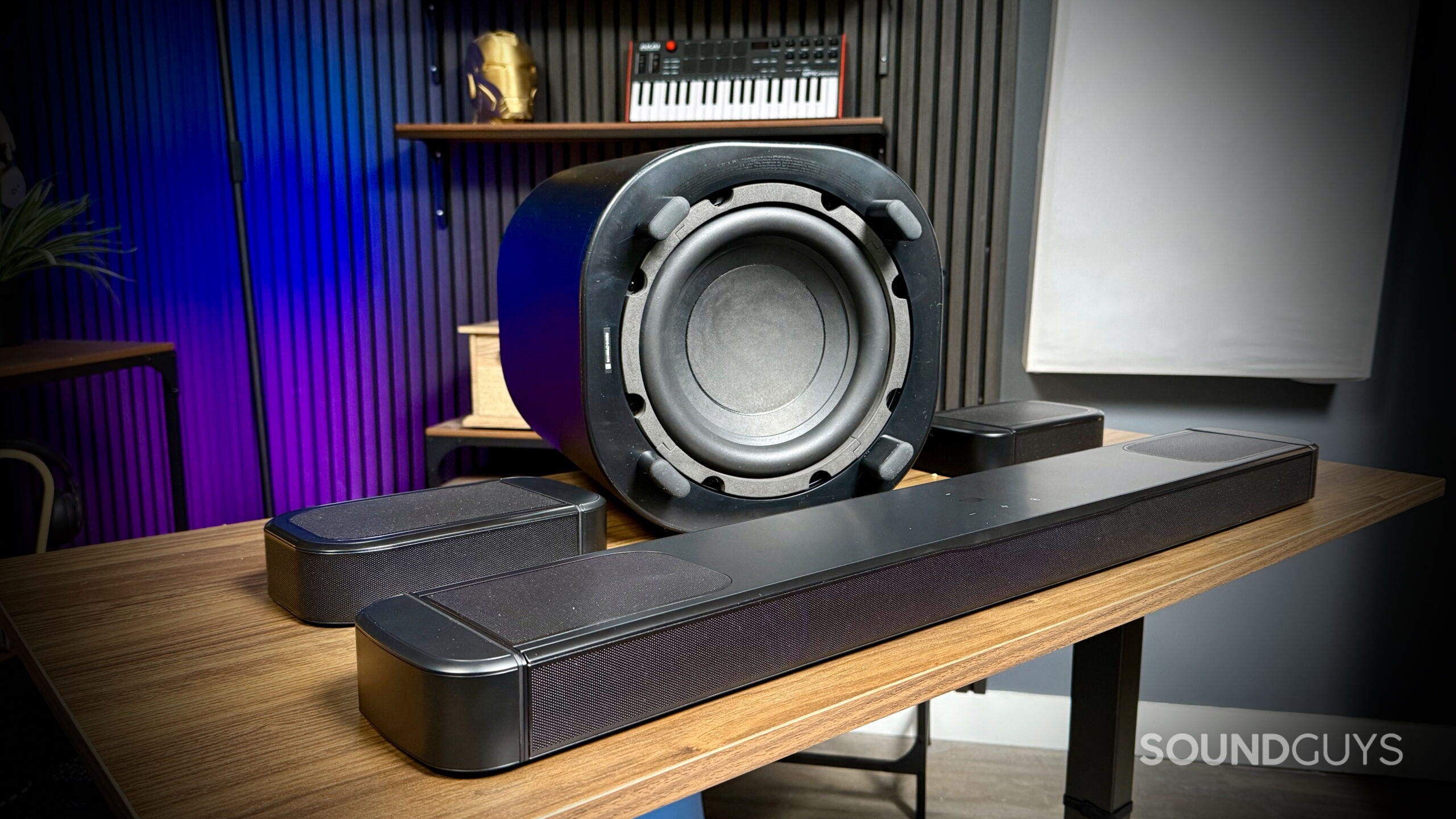 JBL Bar 1000MK2 - 6 Rear view of the JBL BAR 1000MK2 subwoofer with speaker cone exposed, flanked by the soundbar and detachable speakers.