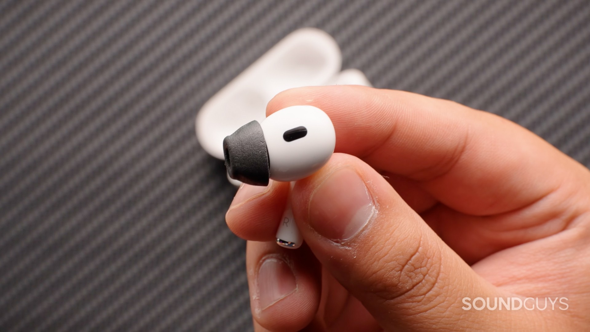 apple airpods pro 2 with foam ear tip AirPods Pro 2 with black foam ear tip in hand
