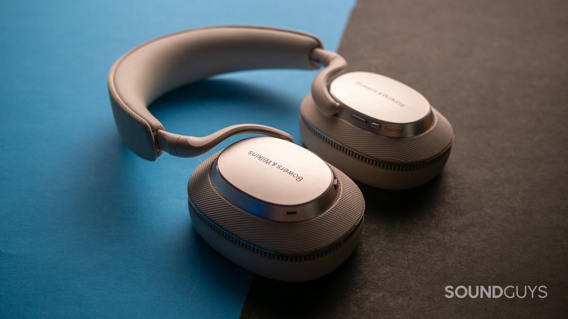 A photo of the Bowers &amp; Wilkins PX7 S3 atop a blue and black background.