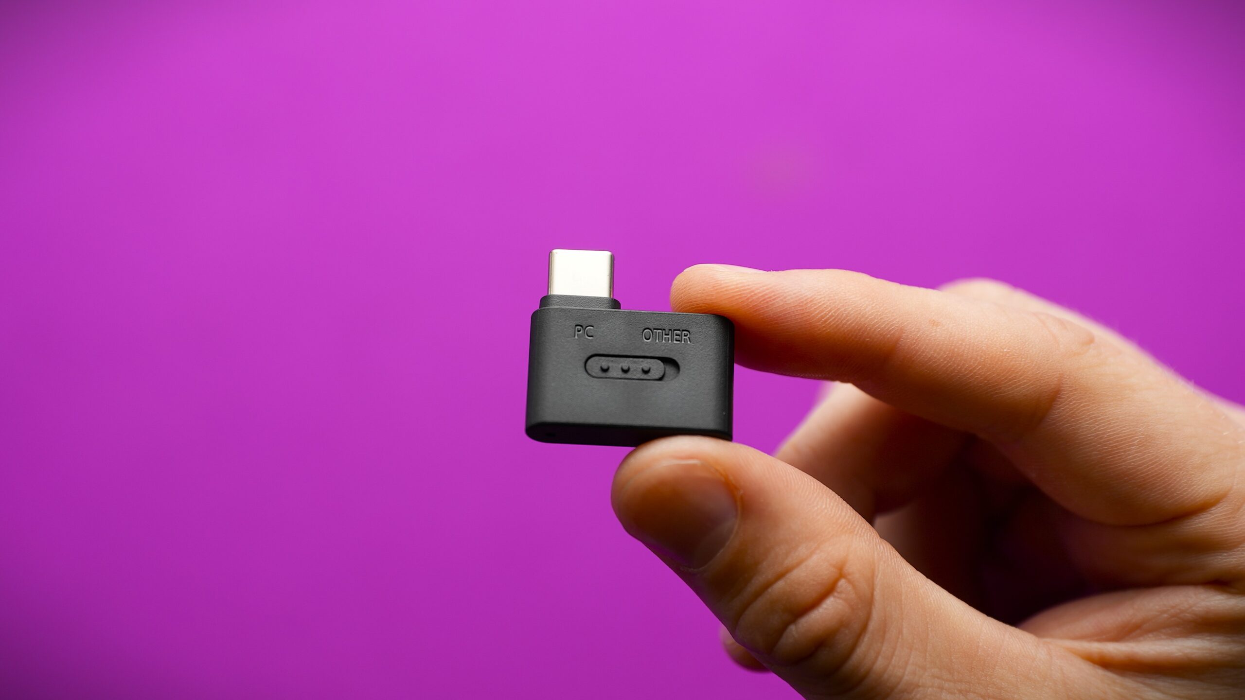 a hand holding the sony inzone h9 II usb dongle
