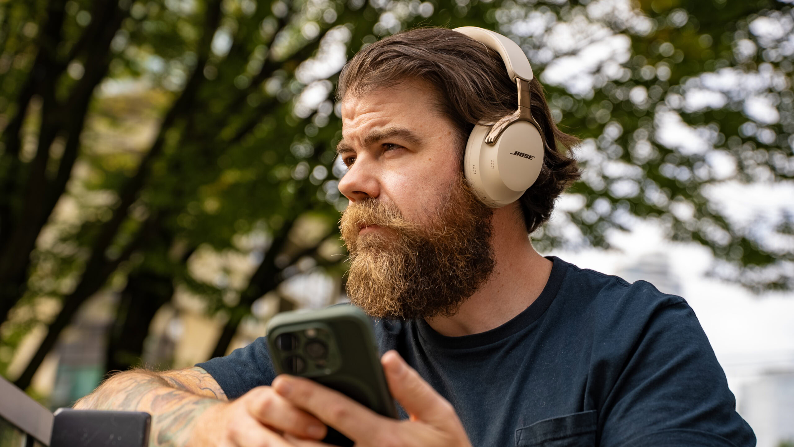 A man listens to the Bose QuietComfort Ultra 2nd Gen. outdoors.