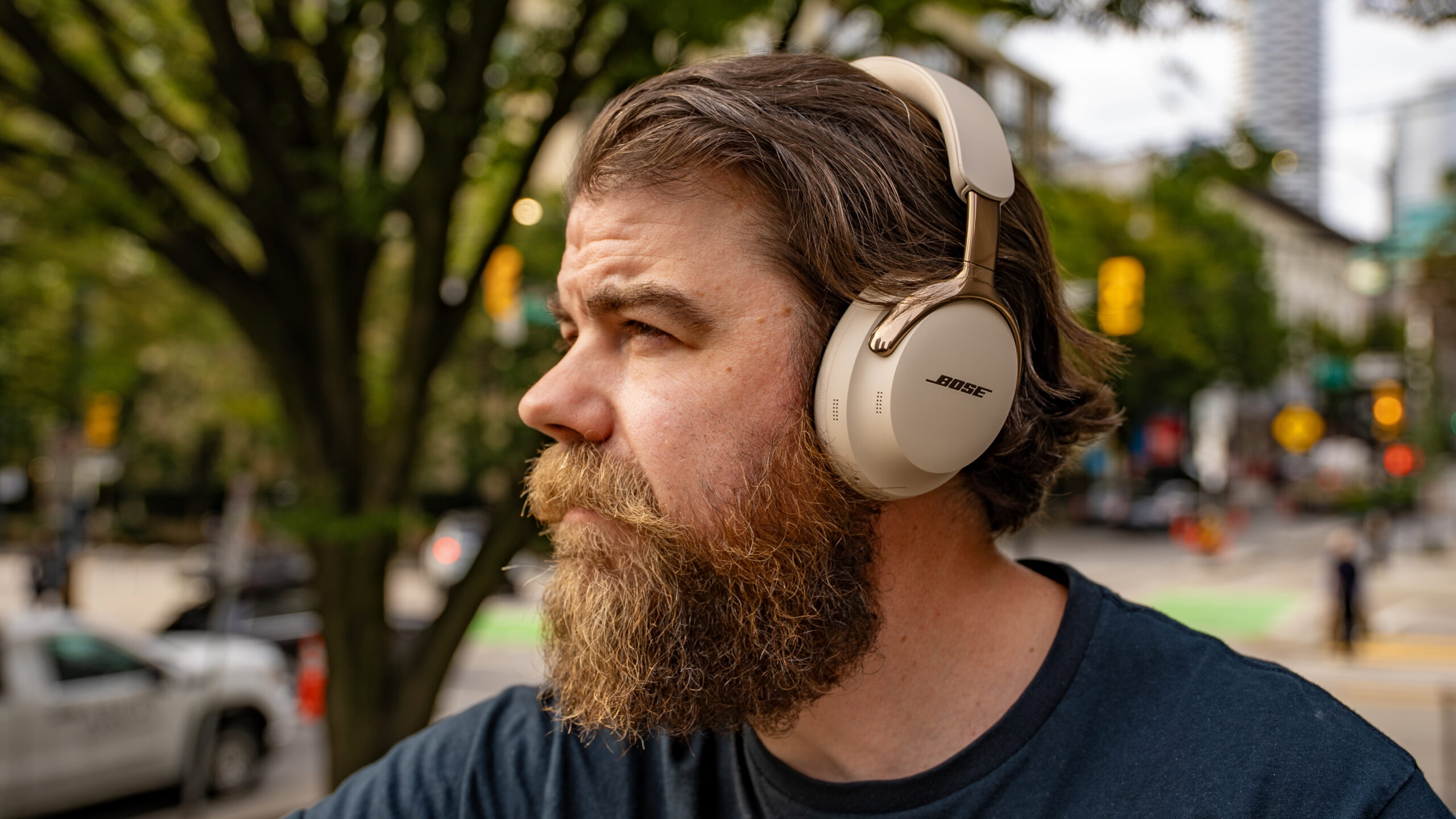 Bose-QuietComfort-Ultra-Headphones-2nd-Gen-man-wearing-looking-left A man listens to the Bose QuietComfort Ultra 2nd Gen. outdoors.
