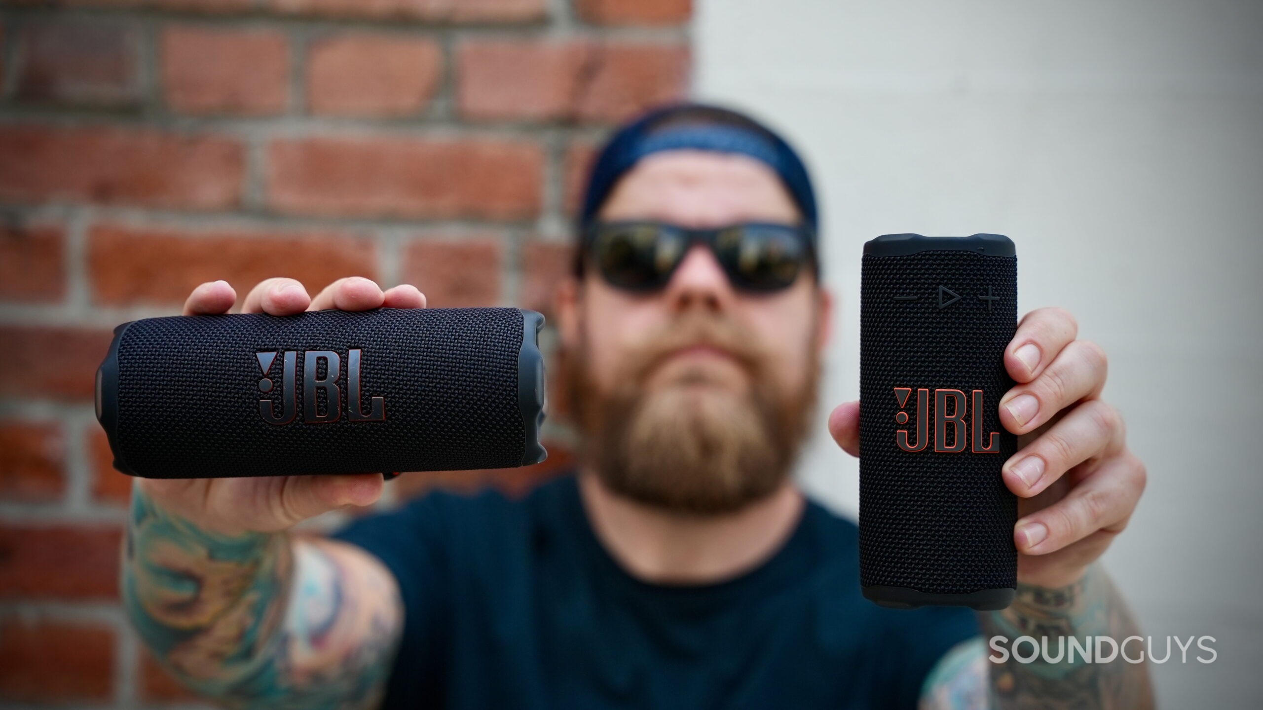 JBL Grip vs Flip 7 - 1 A man holds the JBL Grip in one hand and the Flip 7 in the other.