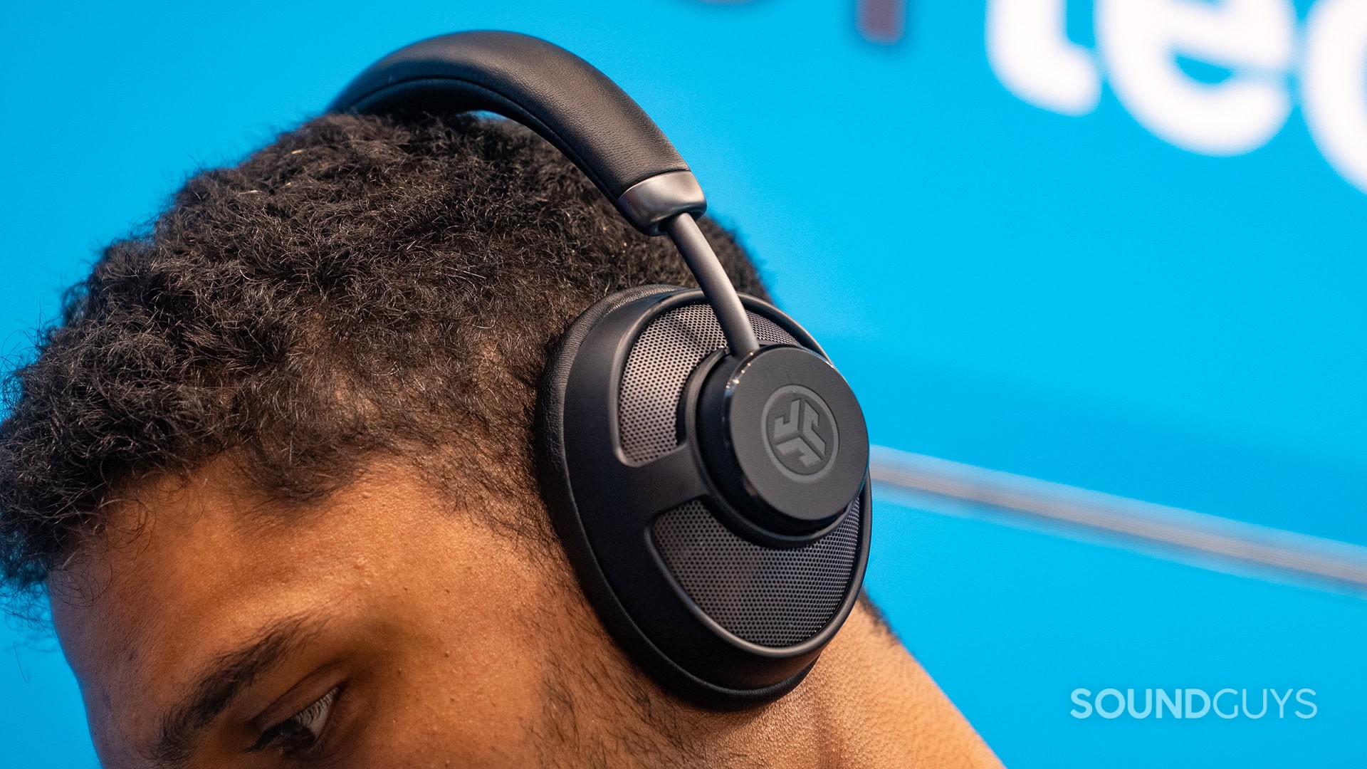 JLab JBuds Open wireless headphones with grille ifa 2025.jpg JLab JBuds Open wireless earbuds on man's head looking down