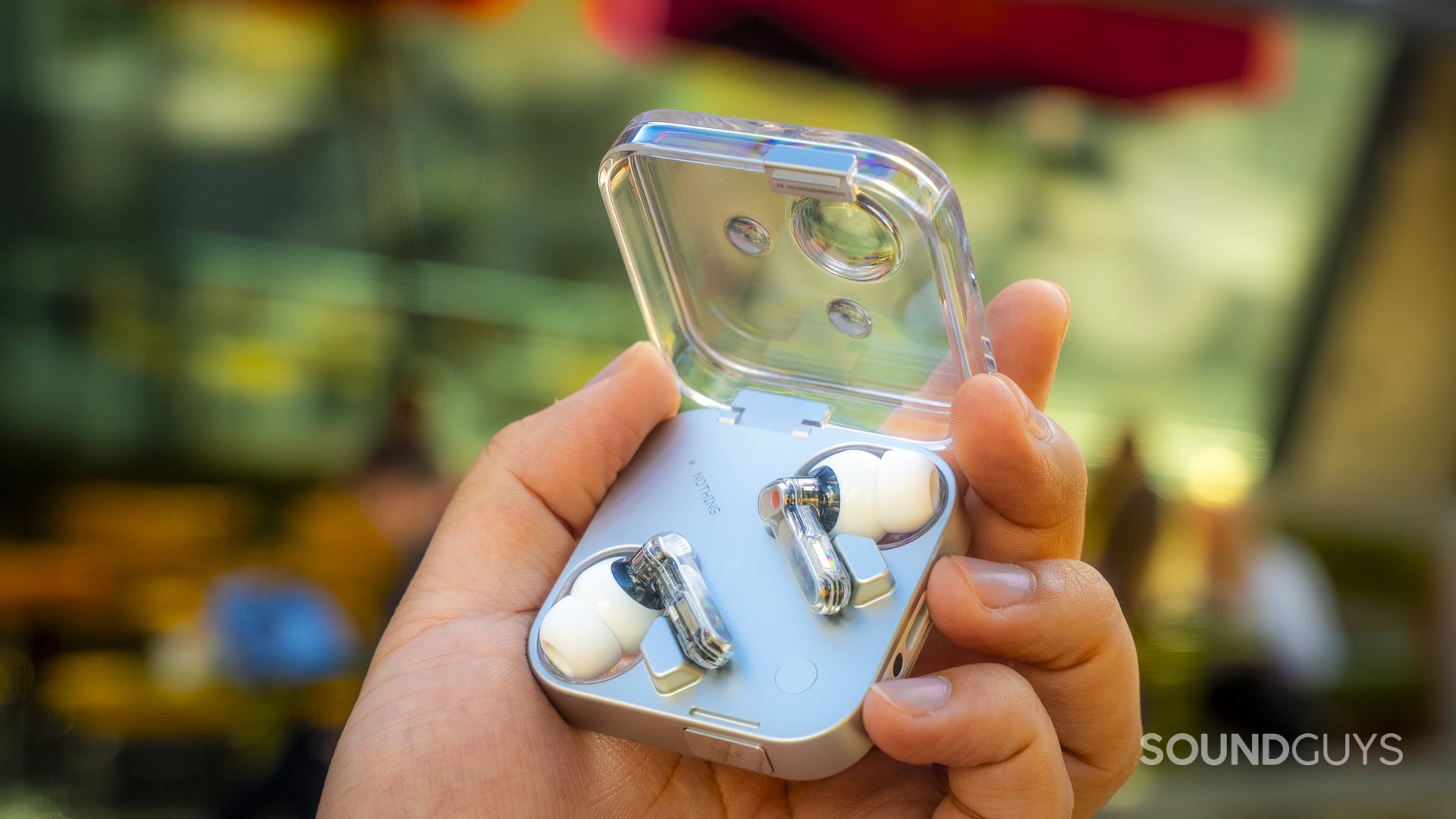 a hand holding the nothign ear 3 in case with the lid open