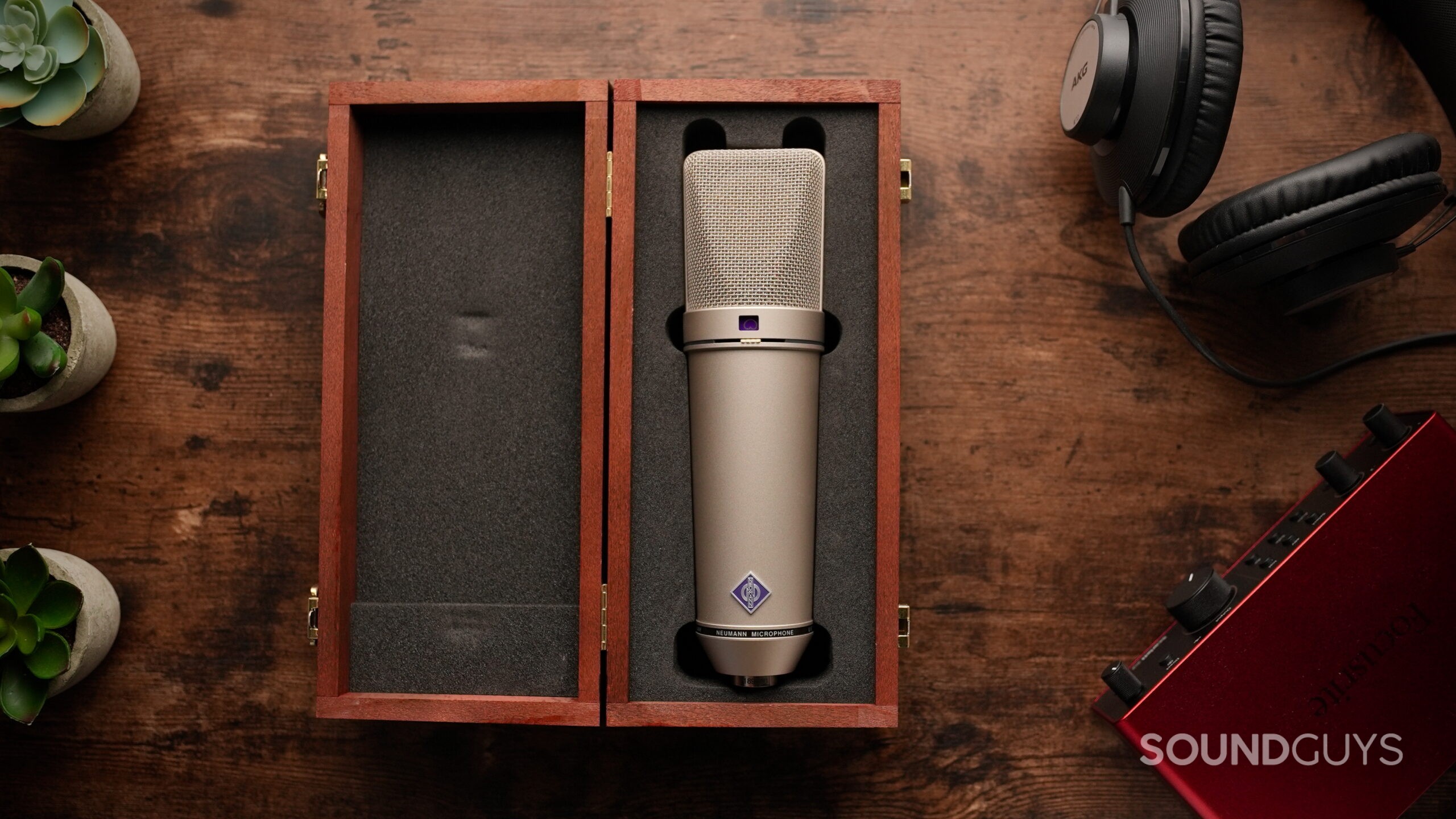 U87 - 8 A Neumann U87 Ai microphone in its wooden box on a wooden table.