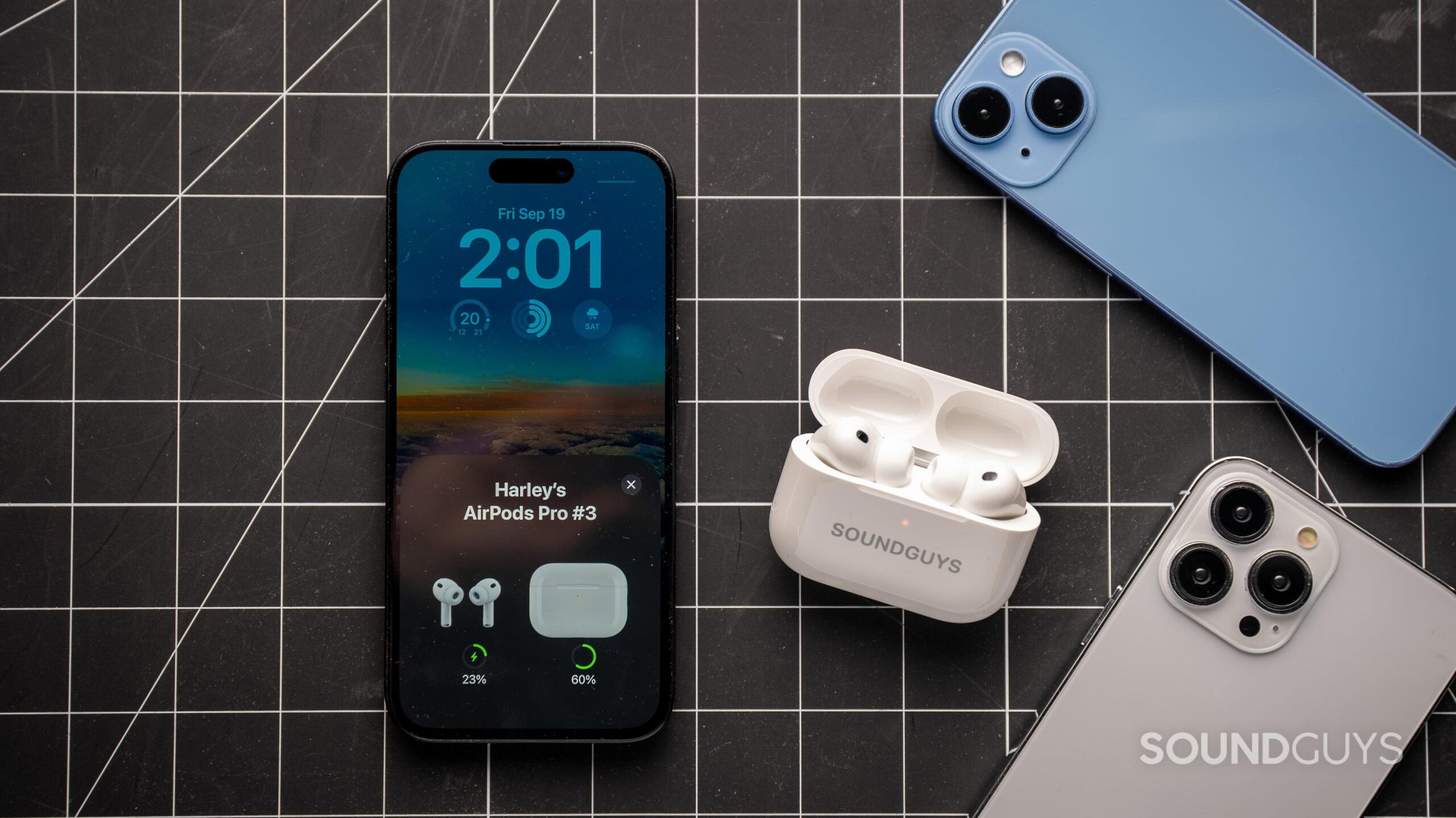 AirPods Pro 3 next to iPhone showing battery life of earbuds and charging case.