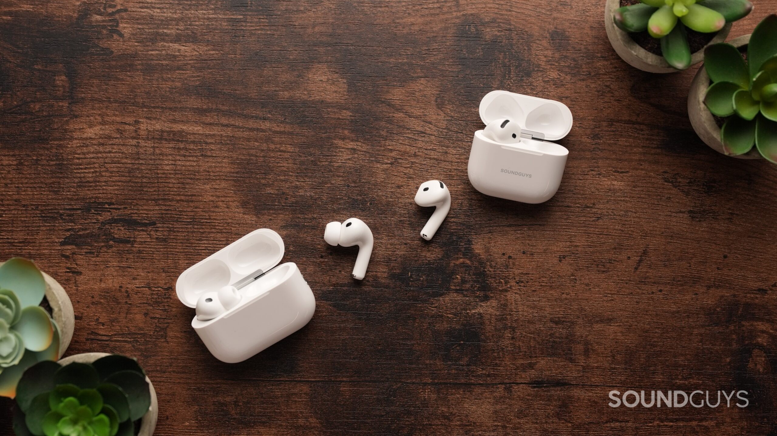 The AirPods Pro 3 and AirPods 4 sit on a table. Each right earbud sits in the centre.