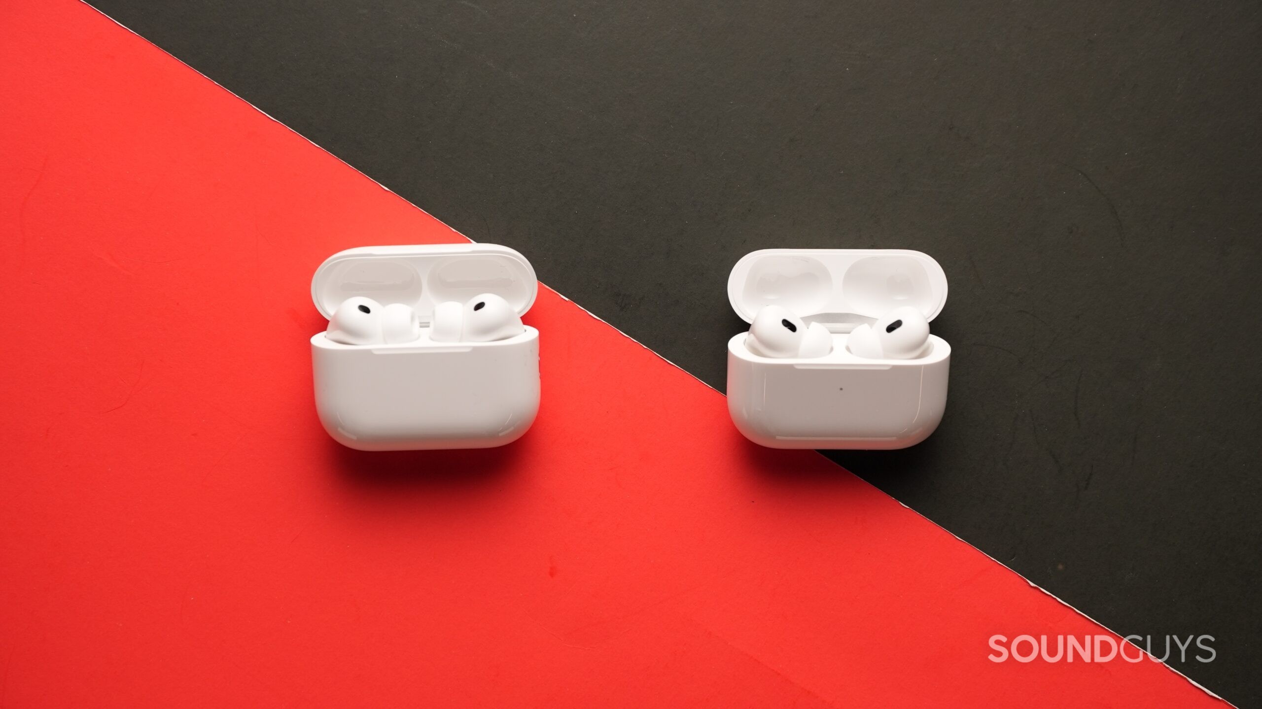 The AirPods Pro 3 and AirPods Pro 2 on a table on a black and red background.