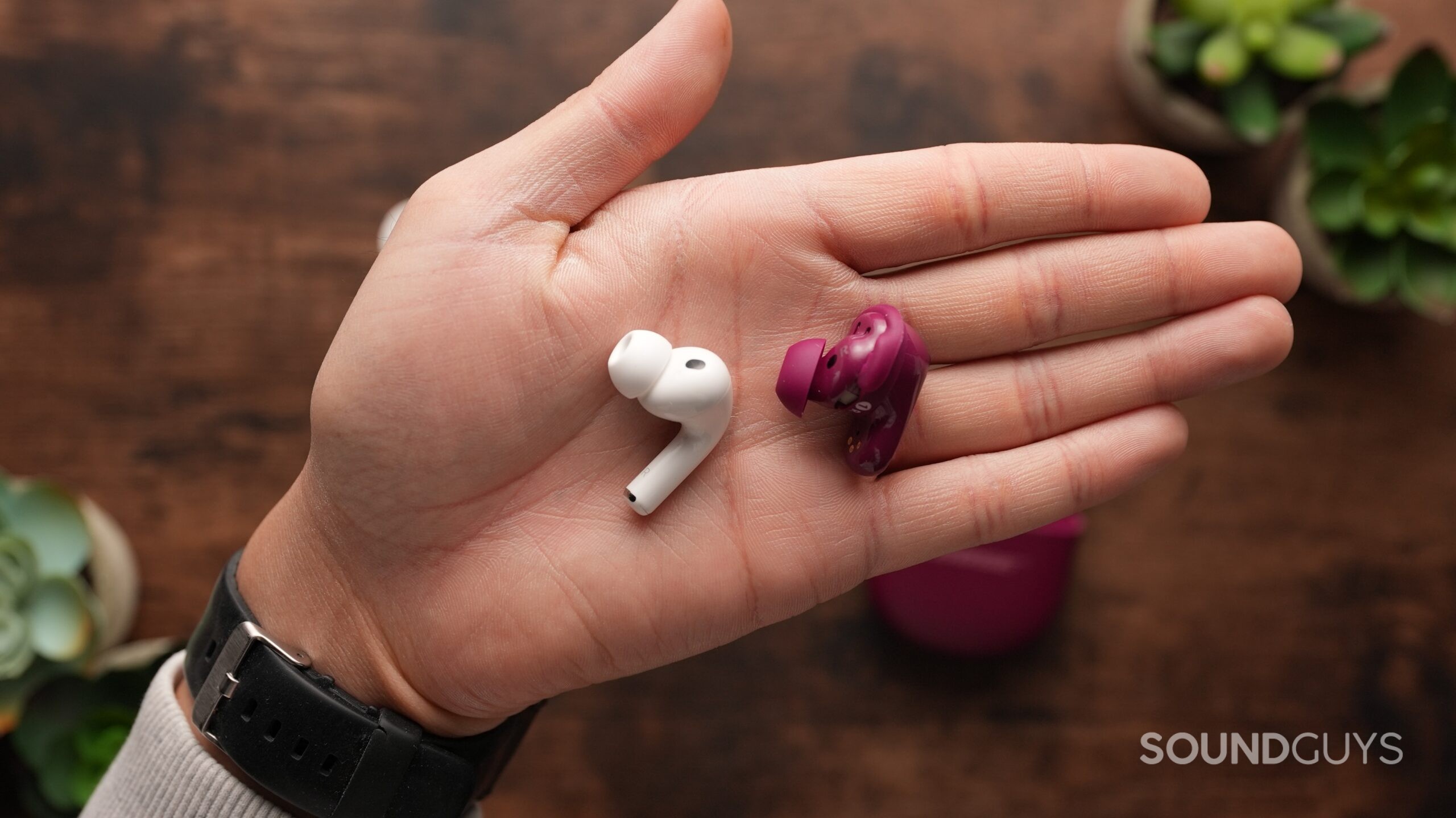 The AirPods Pro 3 and Bose QC Ultra 2 earbuds held in a hand.