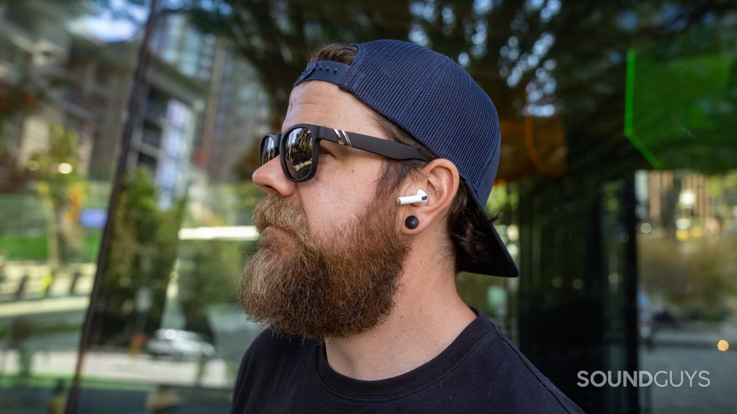 A photograph of a man wearing the Apple AirPods Pro 3.