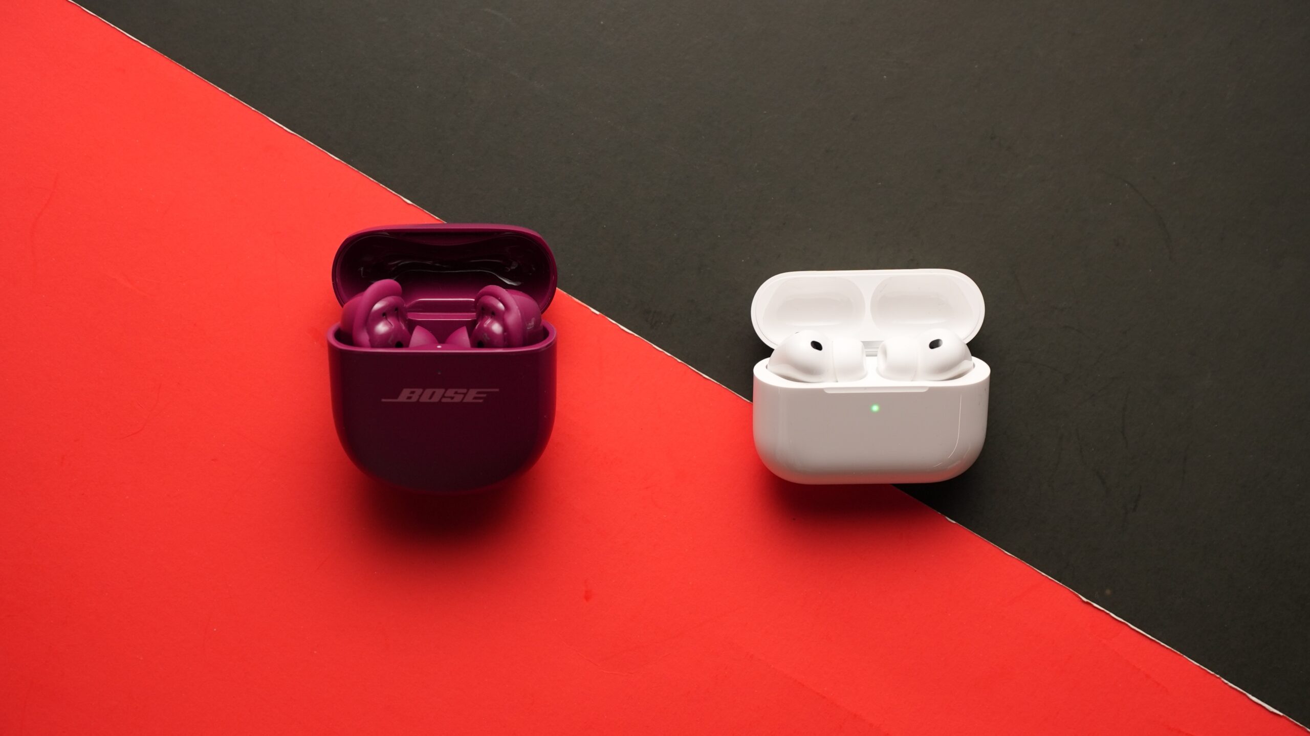 The AirPods Pro 3 and Bose QC Ultra 2 sit on a table. Each right earbud sits in the centre.