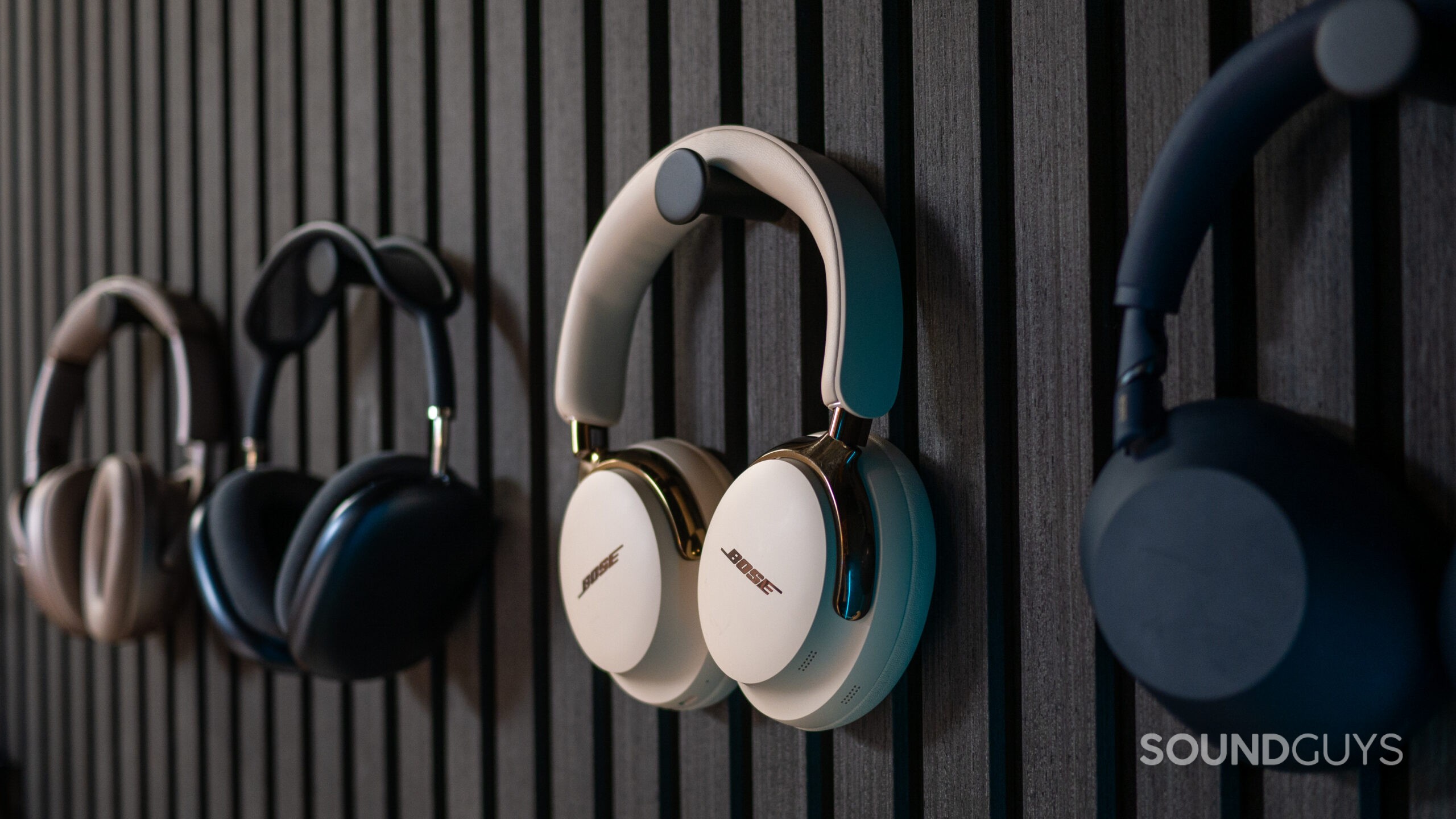 A photo of the Bose QuietComfort Ultra (2nd Gen.) on a headphone stand affixed to a wall.