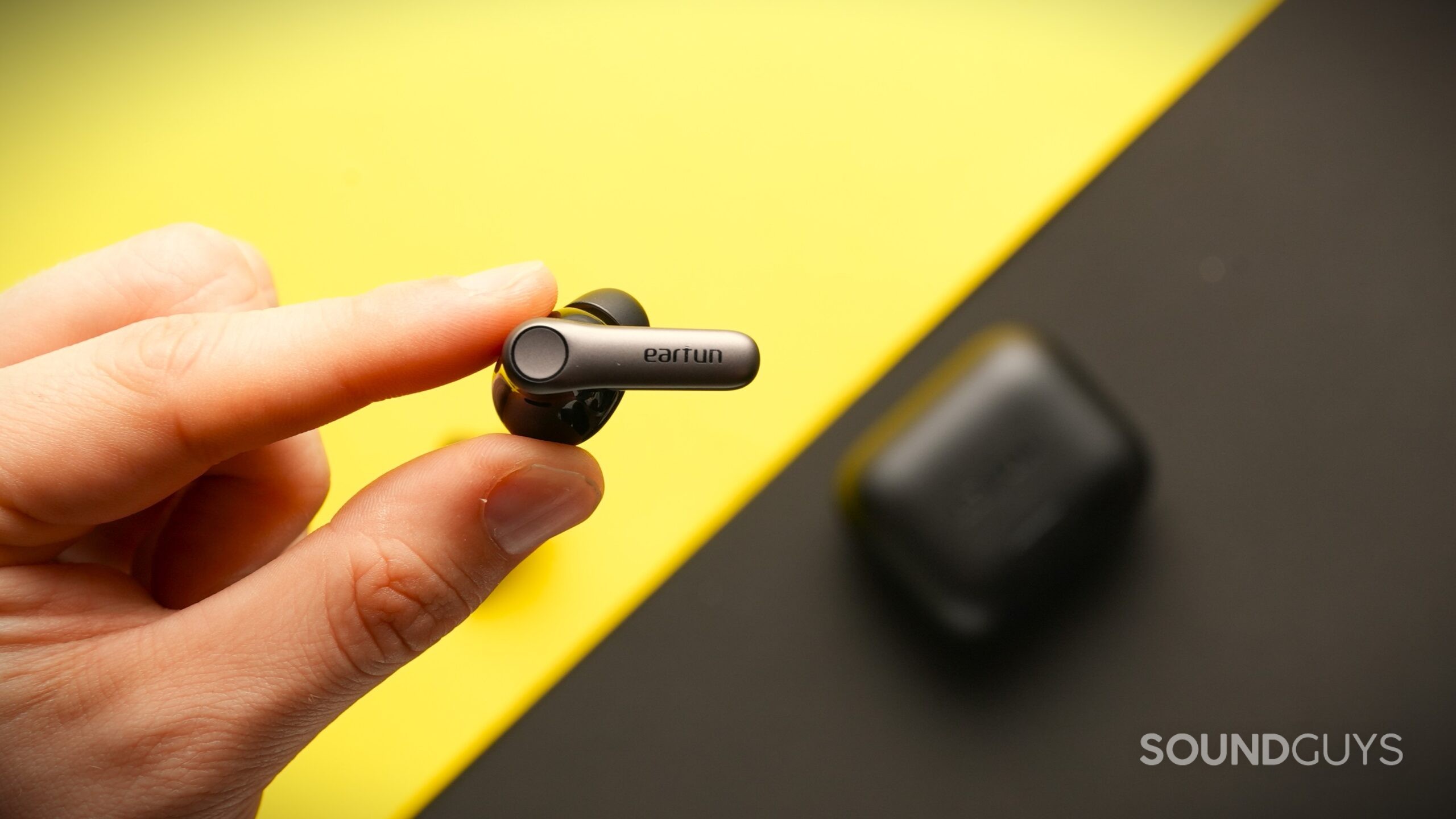 DSC04083 EarFun Air Pro 4+ earbud held in hand above a table.