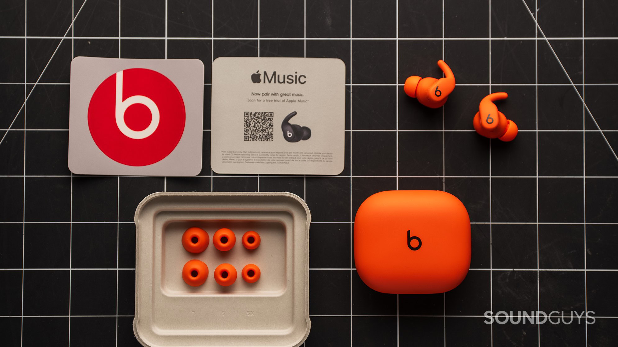 Powerbeats Fit accessories The Powerbeats Fit earbuds with their ear tips, Beats sticker, and Apple Music coupon.