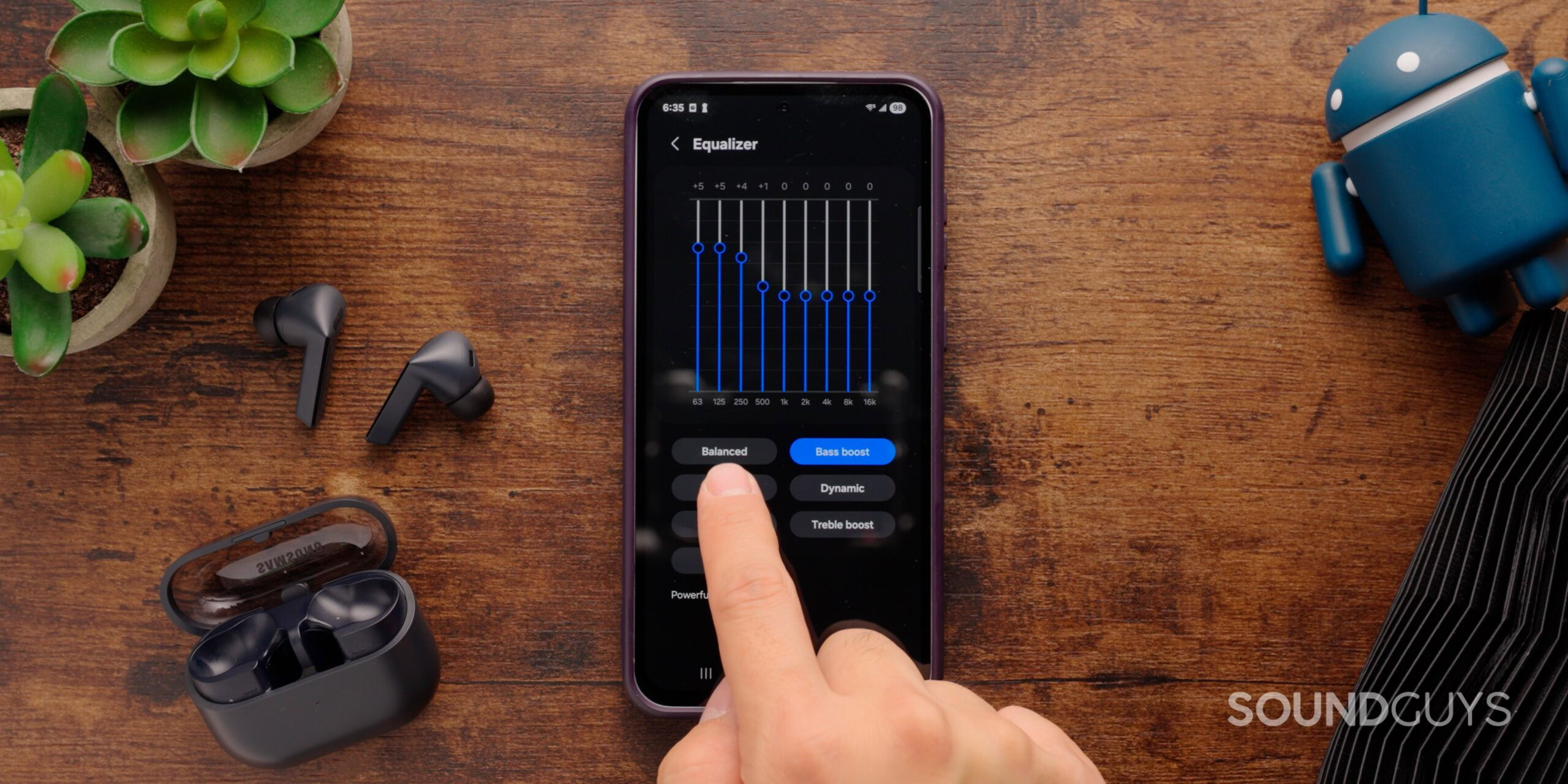 The Galaxy Buds 3 FE sit next to a Samsung phone, connected to the Samsung Wearable app.