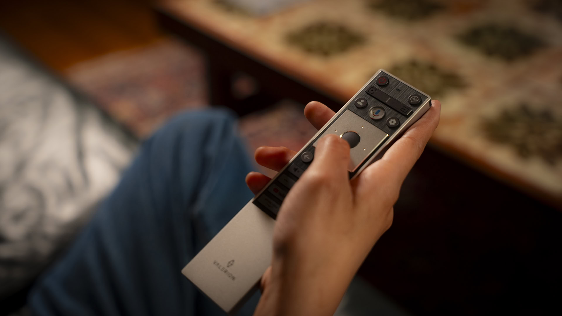 SG_Valerion VisionMaster Pro 2-05 Woman's hand on a couch using remote controller watching a movie using Valerion Visionmaster Pro 2 projector