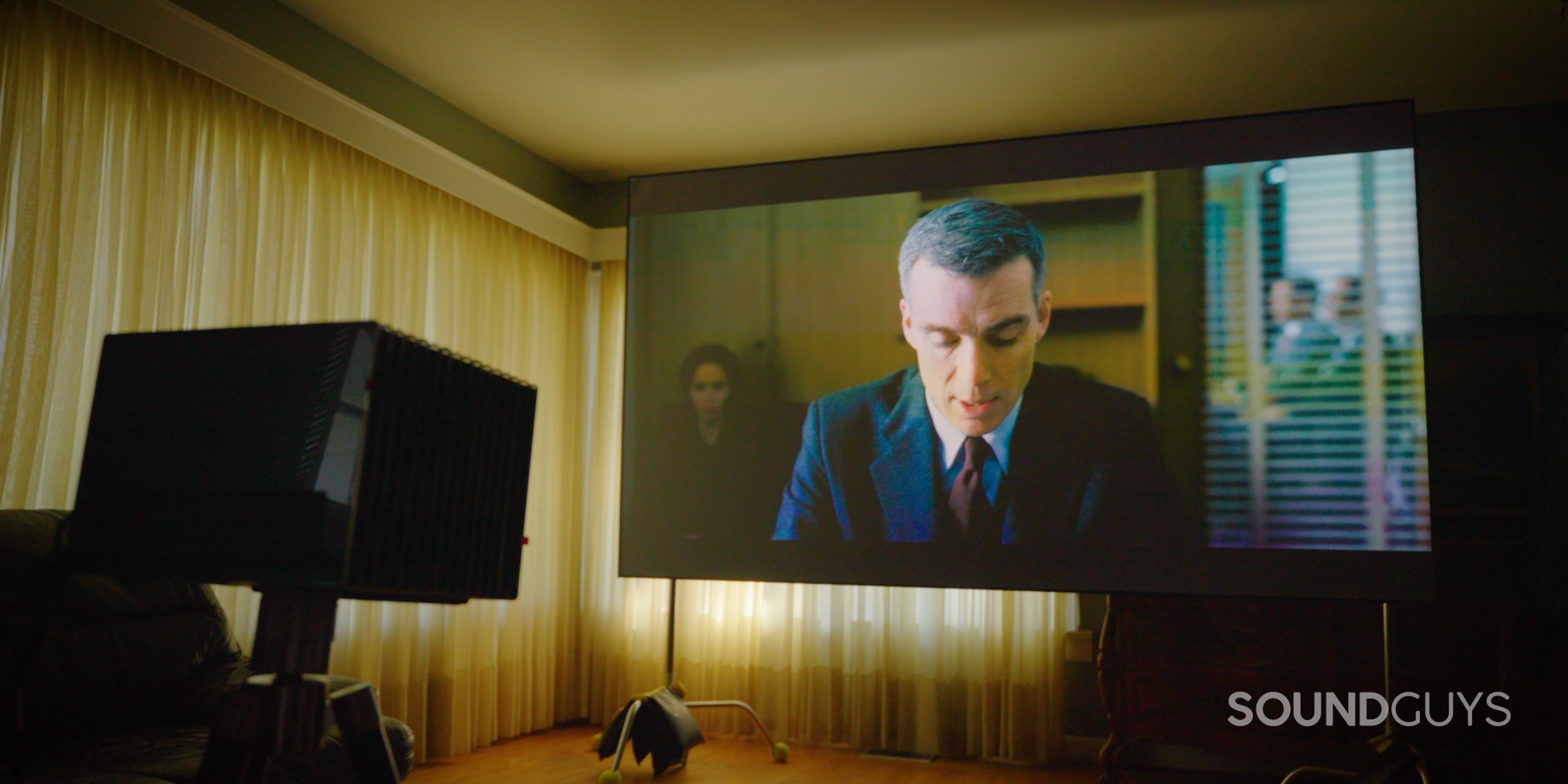 SG_Valerion VisionMaster Pro 2-12 Watching a movie, Oppenheimer, using Valerion Visionmaster Pro 2 projector on Valerion Walnut Tripod Stand in living room with Valerion 120" Fresnel Ambient Light Rejecting Screen on stands